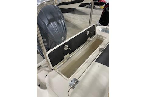 2022 Robalo R247 Dual Console boat storage compartment with open lid, showcasing interior space.