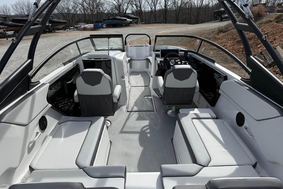 2026 Yamaha Boats AR250 interior with modern seating and steering, parked outdoors.