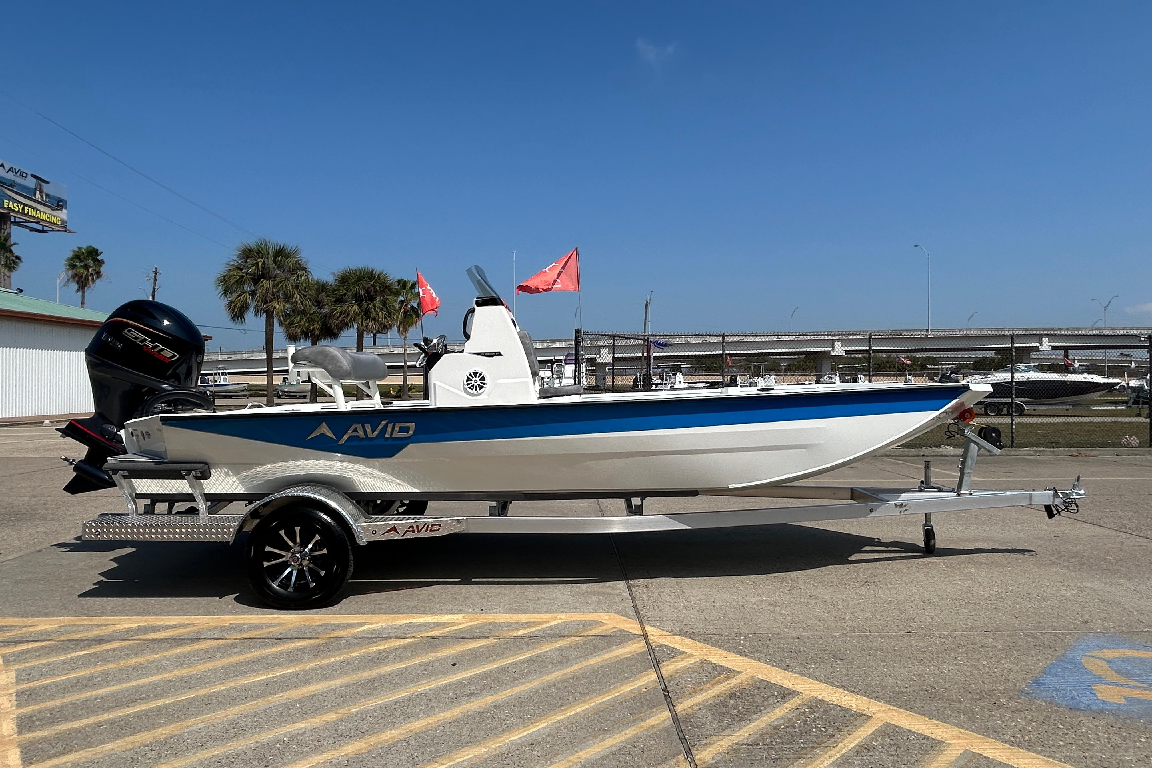 2026 Avid 21 Recon boat on trailer, parked outdoors under clear blue sky.