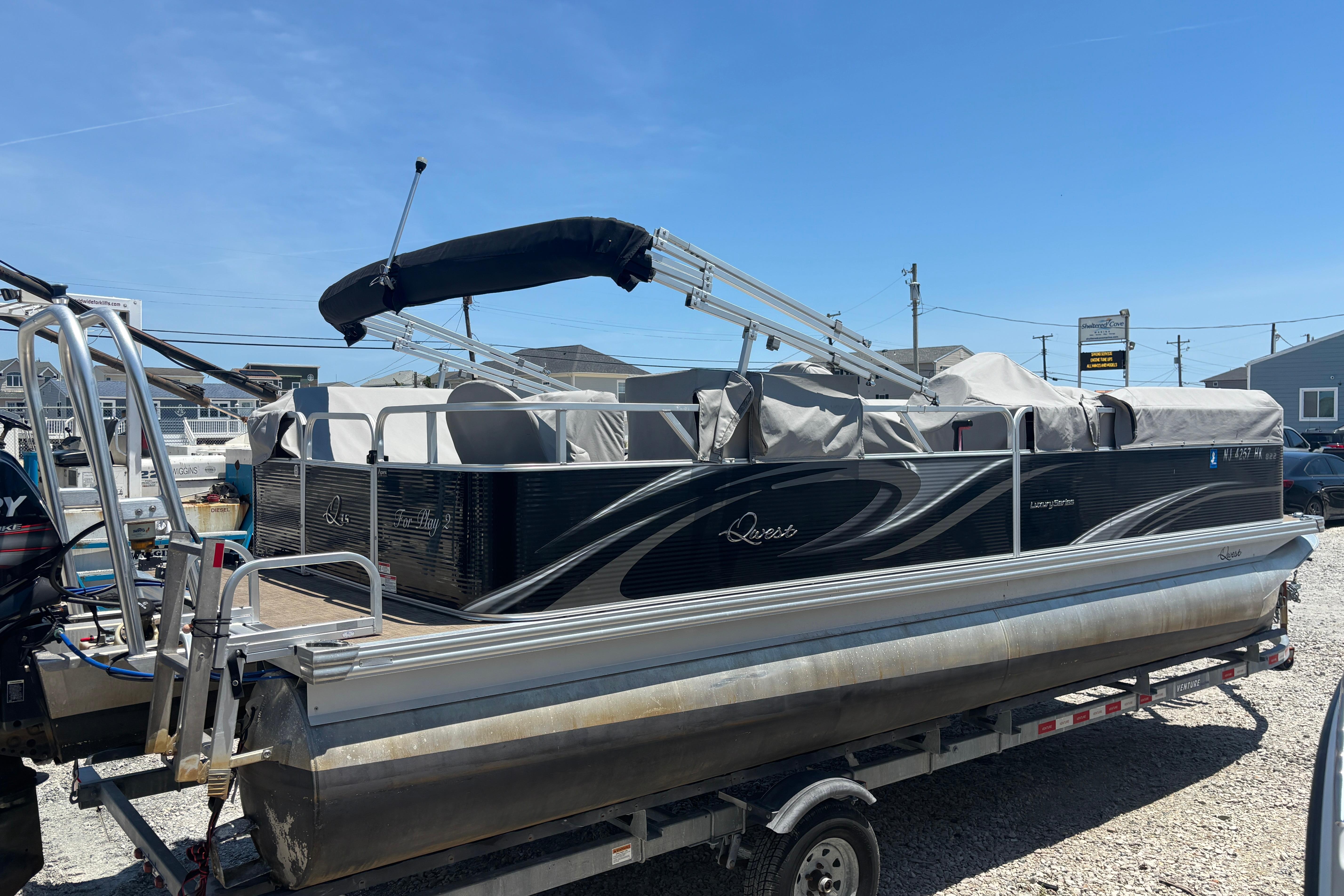 2017 Qwest LS 822 Bar pontoon boat on trailer, covered and parked outdoors.