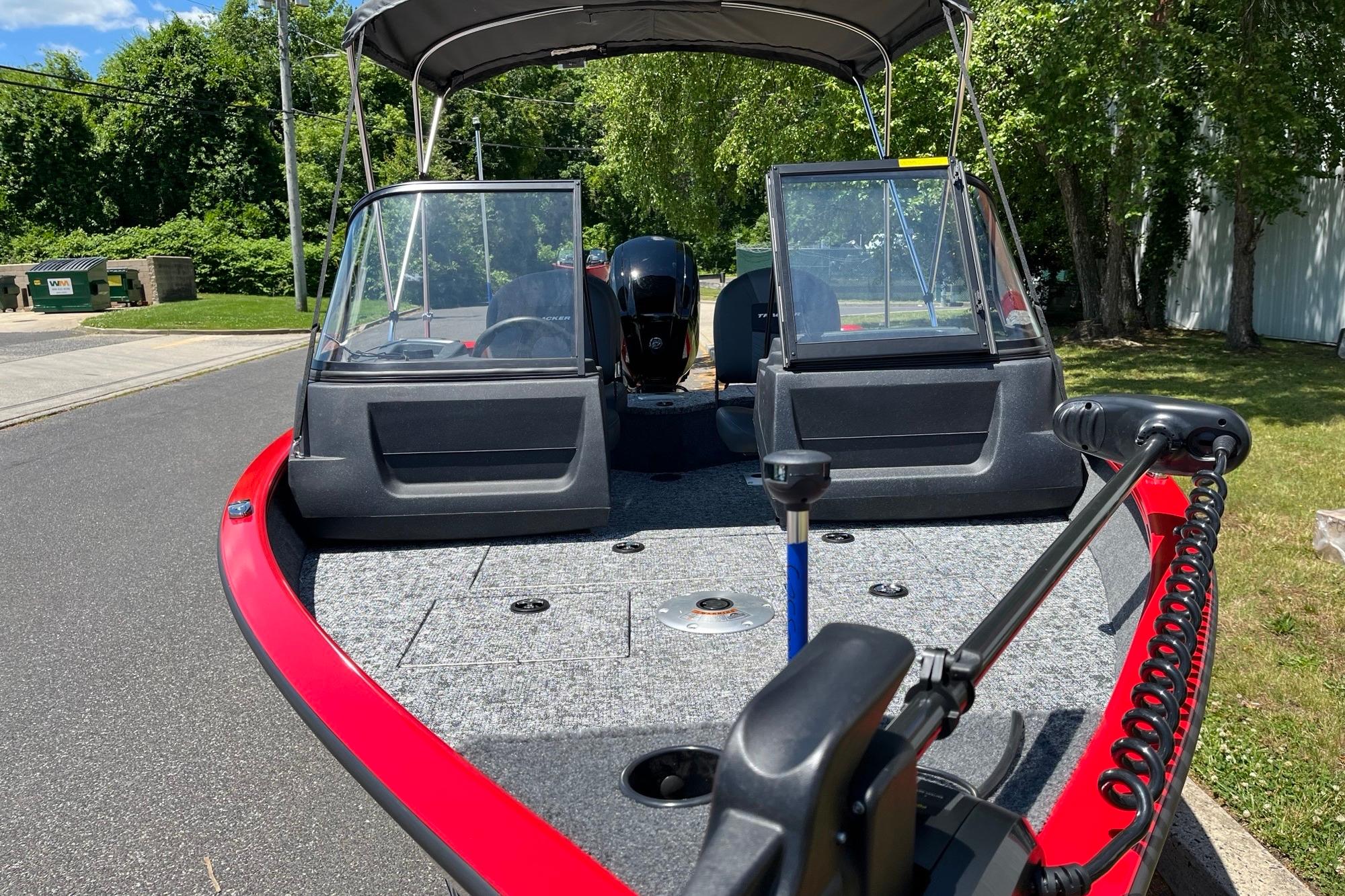 2026 Tracker Pro Guide V-16 WT boat with red trim, parked on a sunny day.