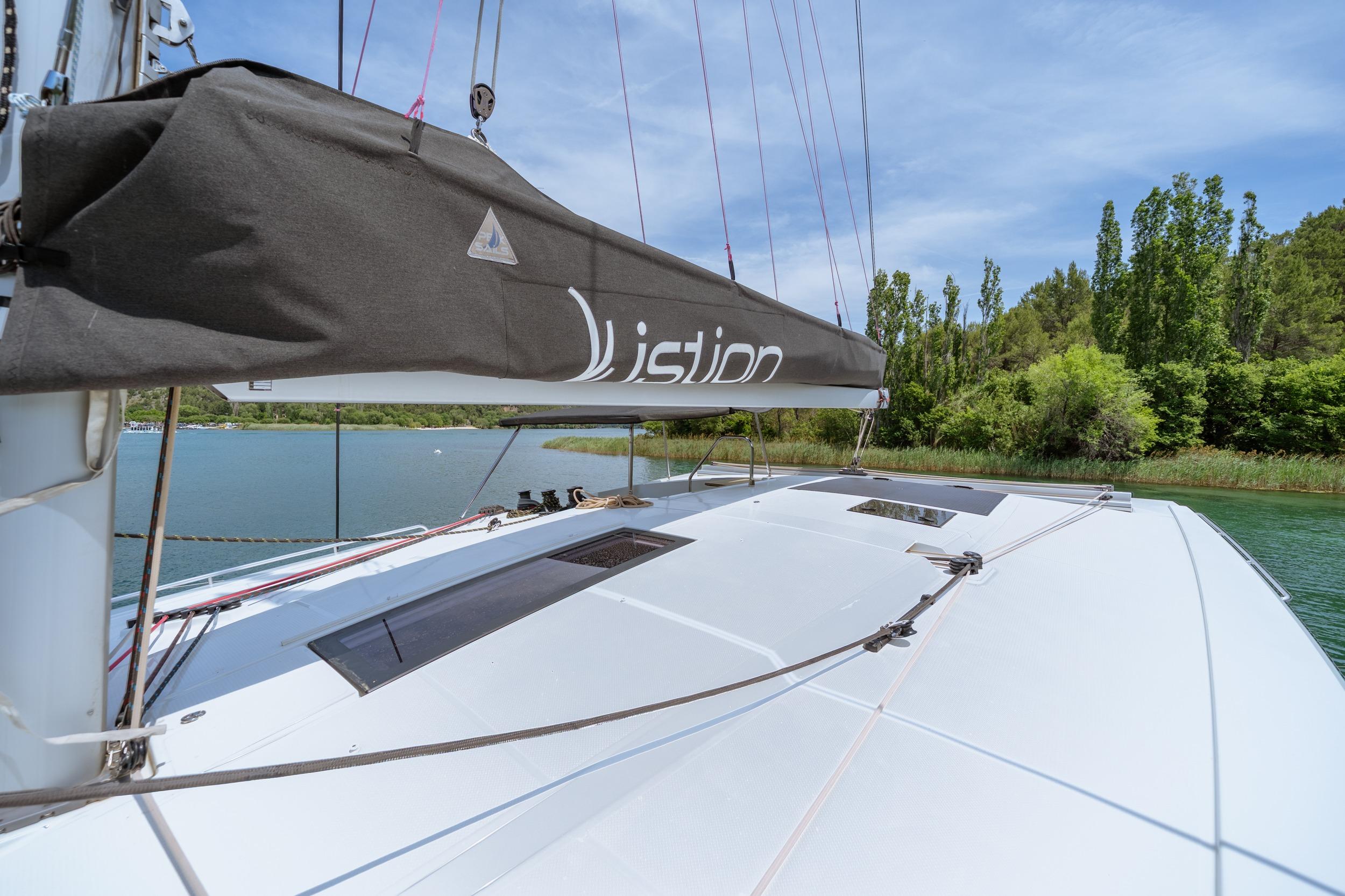 2024 Fountaine Pajot Isla 40 catamaran on serene water, surrounded by lush greenery.