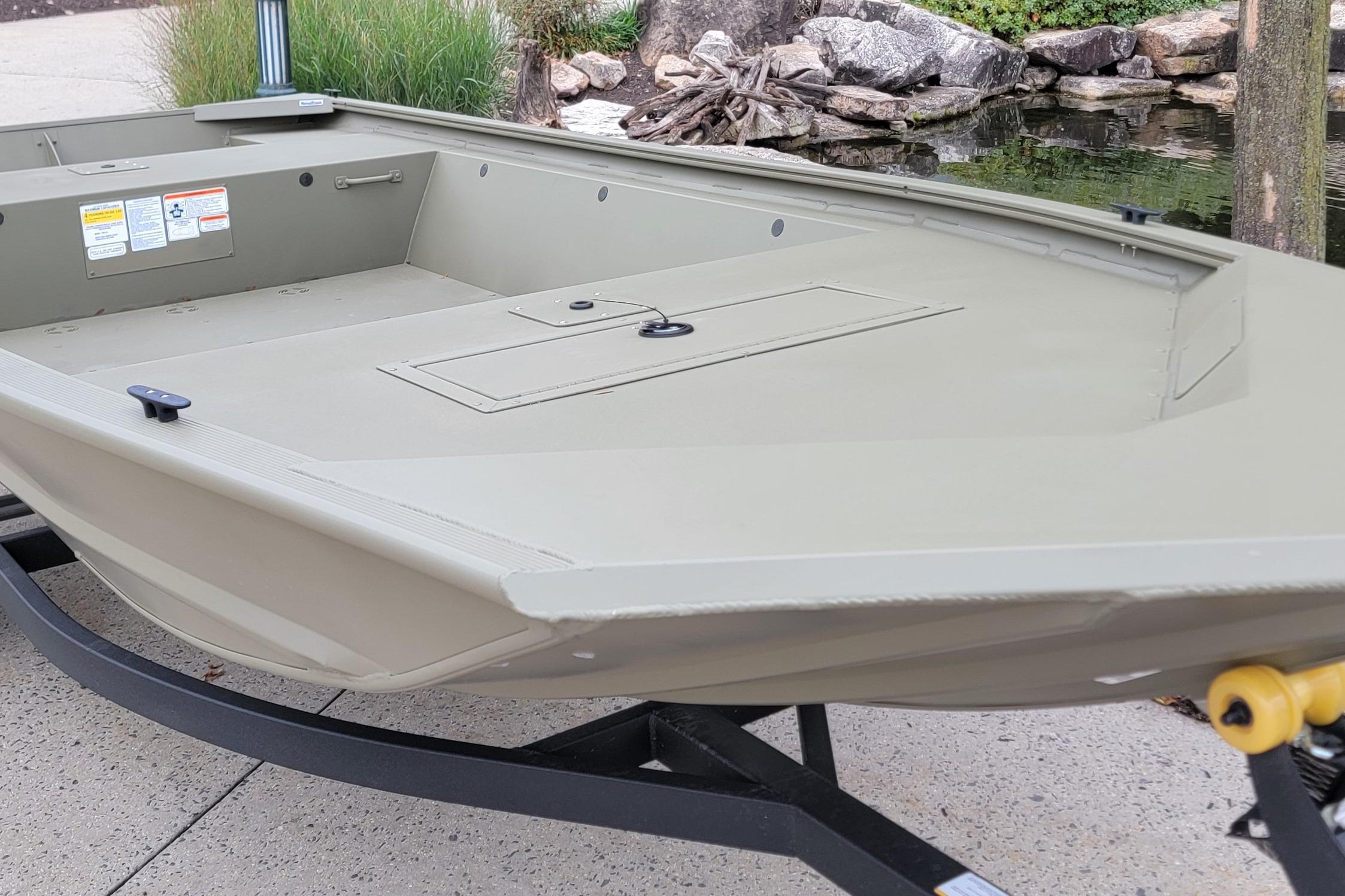 2026 Tracker Grizzly 1648 Utility boat on trailer near a pond.