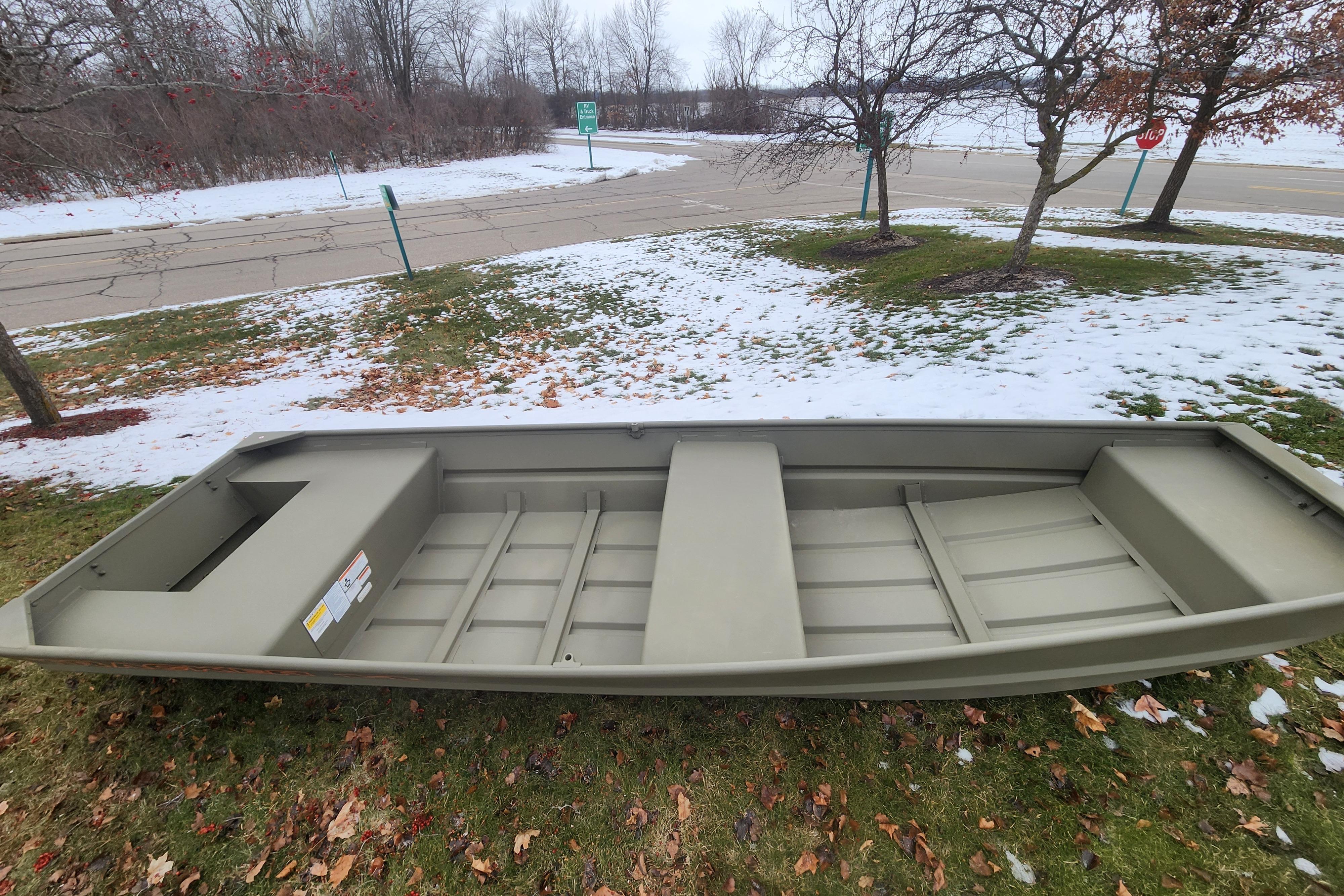 2026 Tracker Grizzly 14 Jon boat on snowy grass, showcasing its sturdy design.