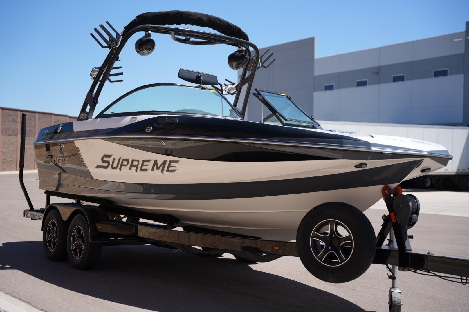 2016 Supreme S211 boat on trailer, sleek design, parked outdoors.