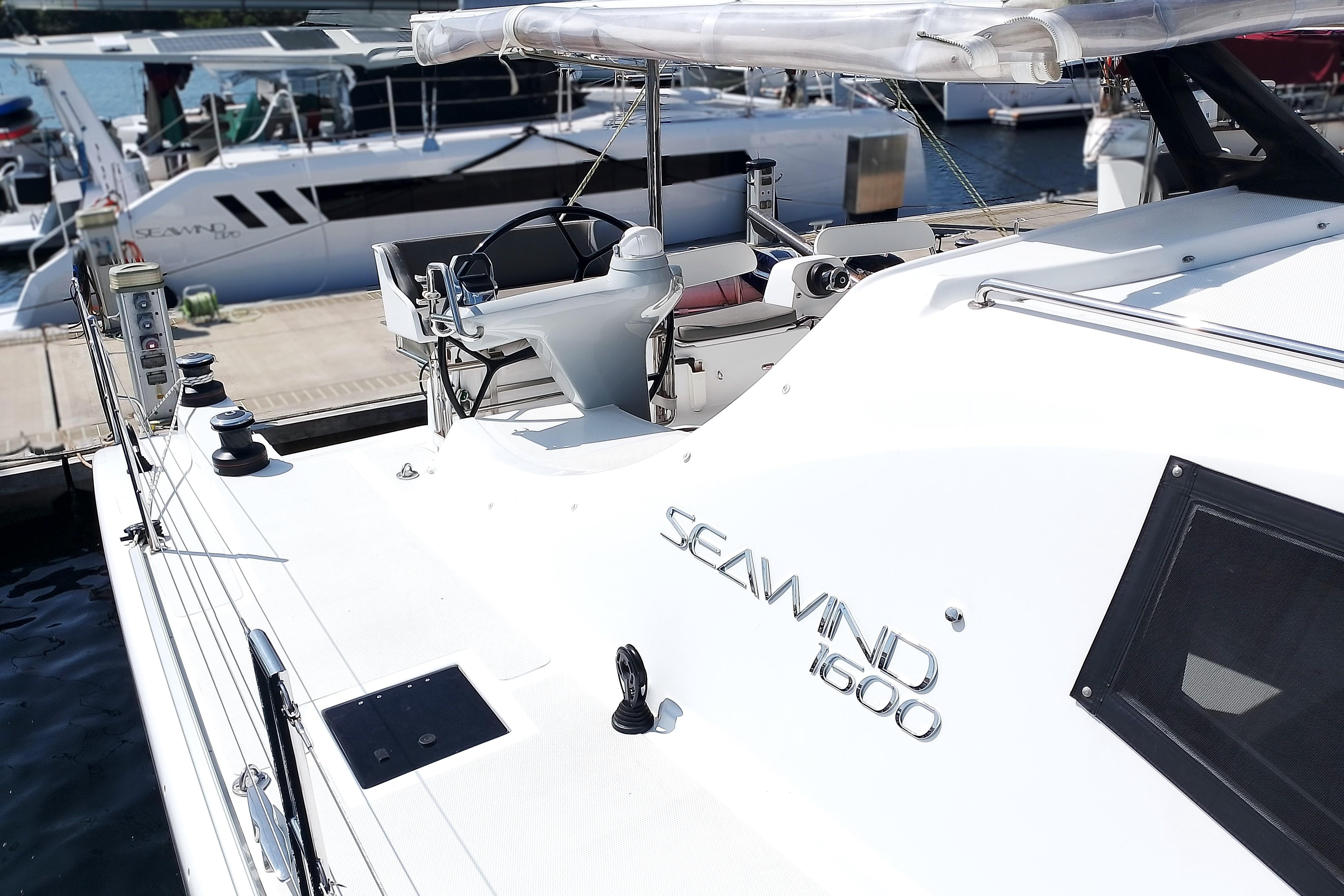 2023 Seawind 1600 Passagemaker yacht docked at marina, showcasing sleek design and helm station.