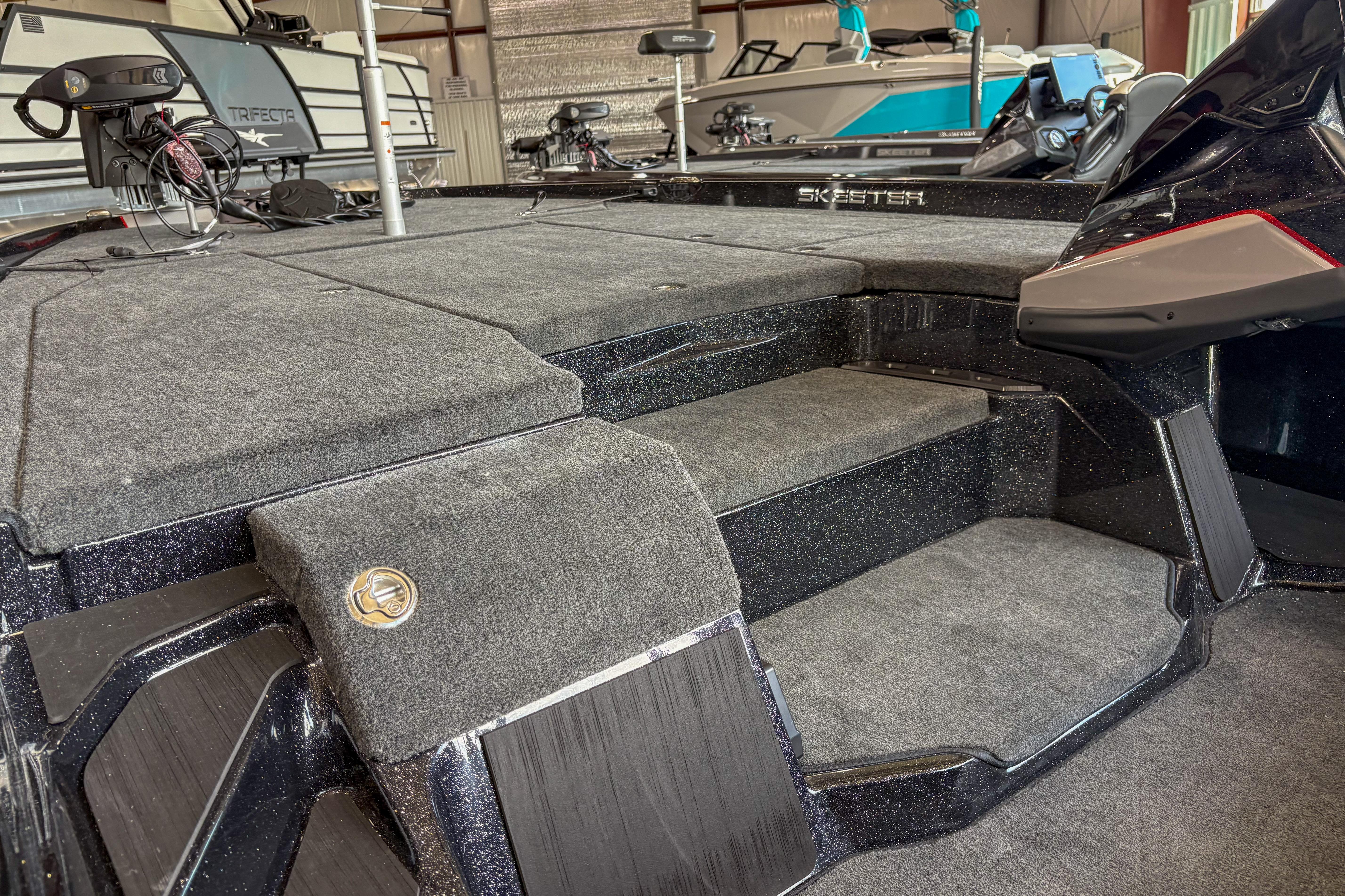 2026 Skeeter ZXE20 boat interior with carpeted steps and deck in a showroom.