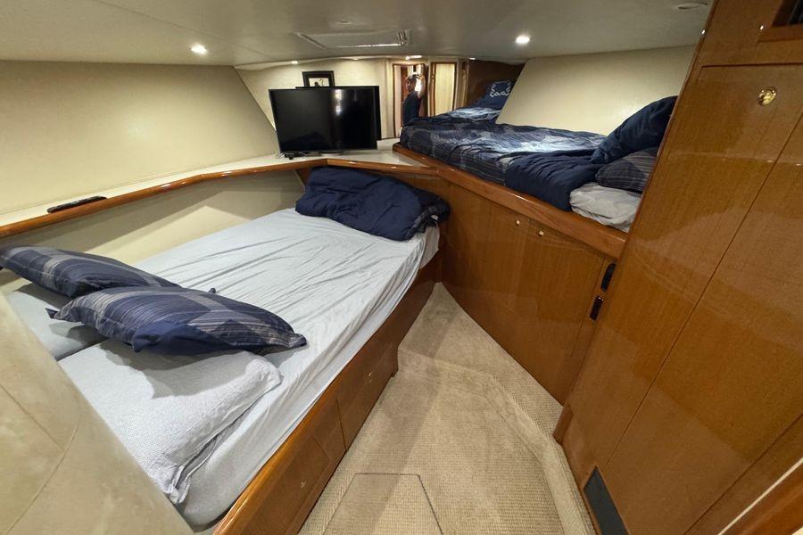 Interior cabin of 2002 Viking 61 Enclosed Bridge yacht with twin beds and TV.
