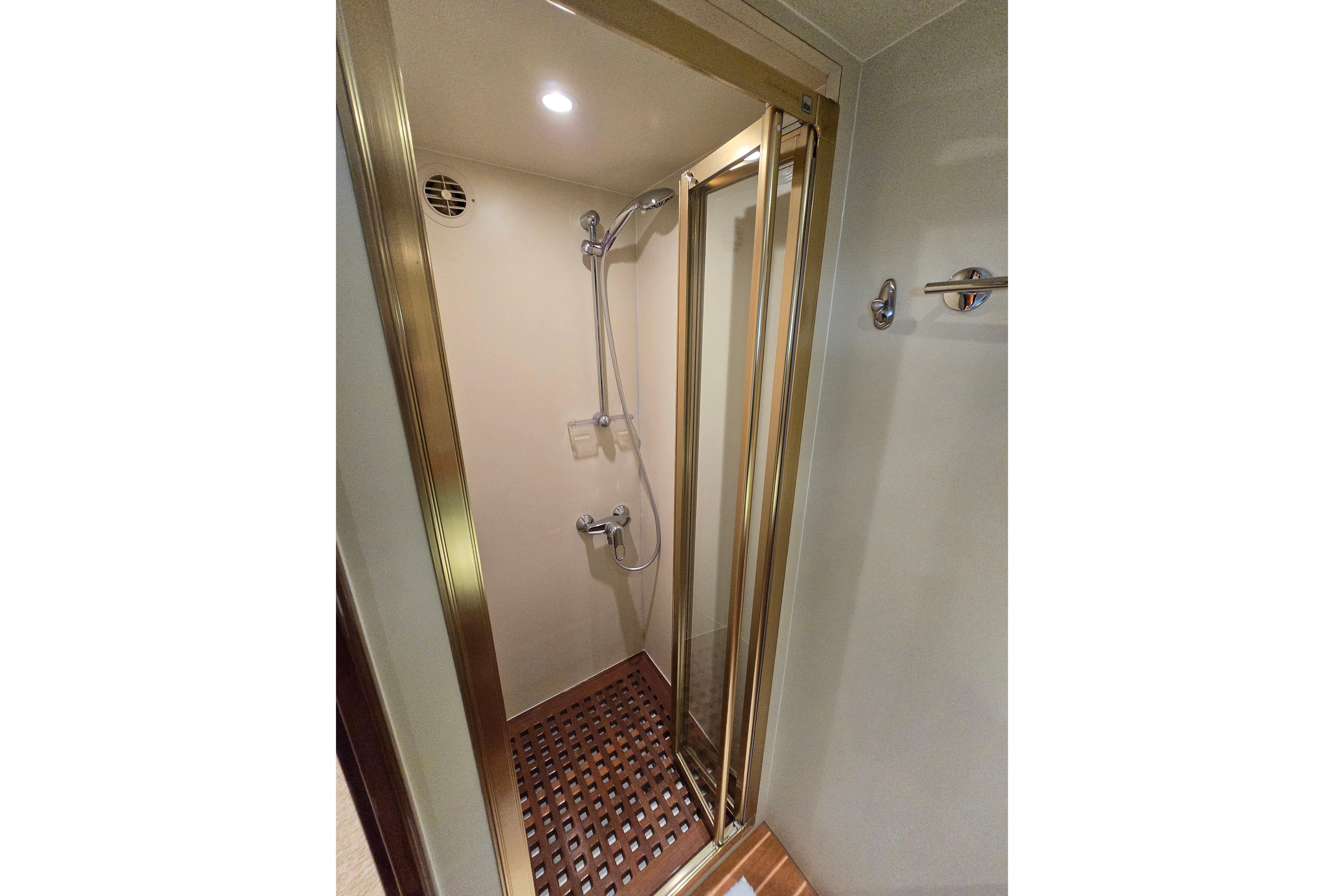 Shower area in 2004 Grand Harbour 58 yacht with glass door and wooden floor.