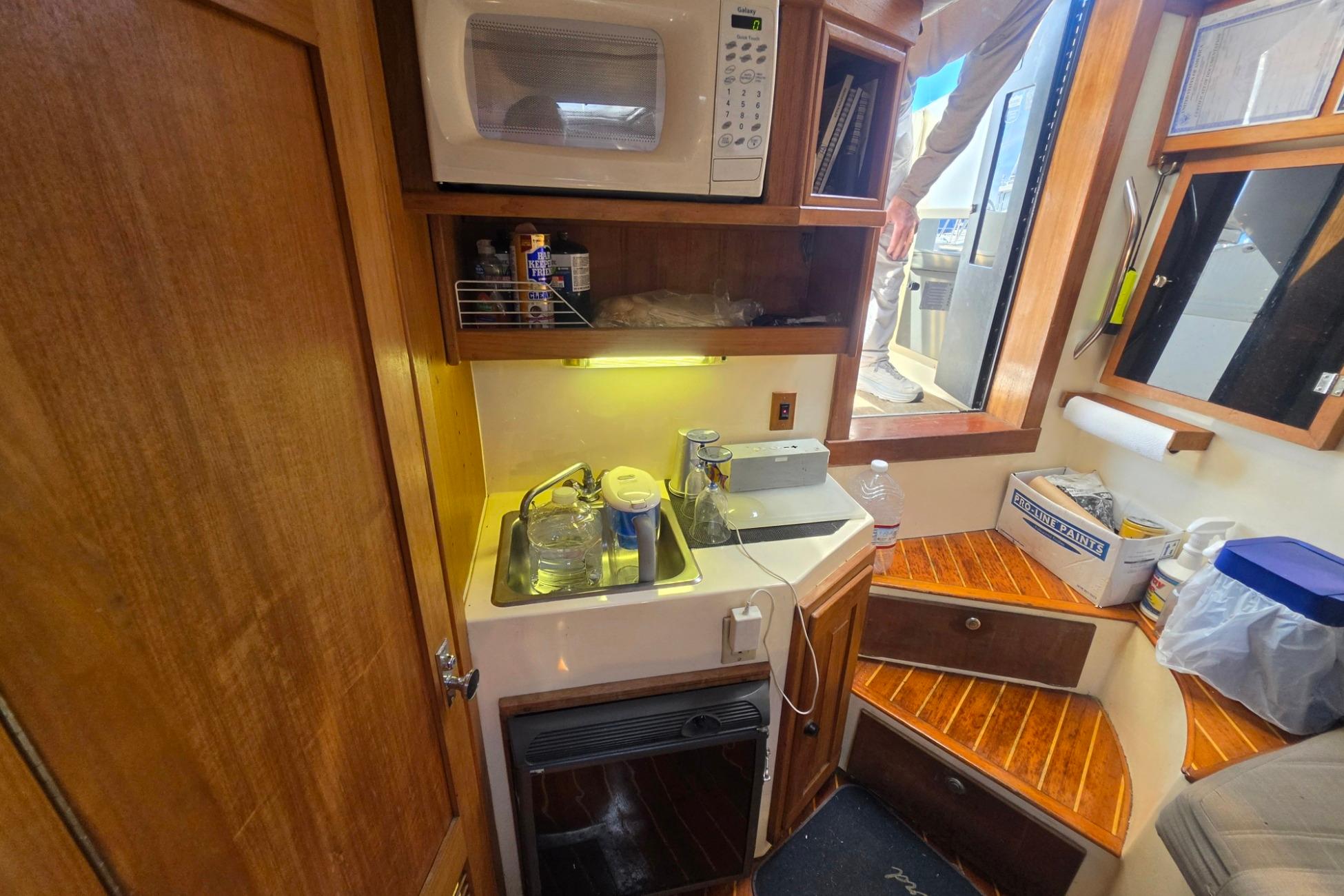 1999 Albemarle 305 Express Fisherman boat interior with kitchenette and wooden cabinetry.