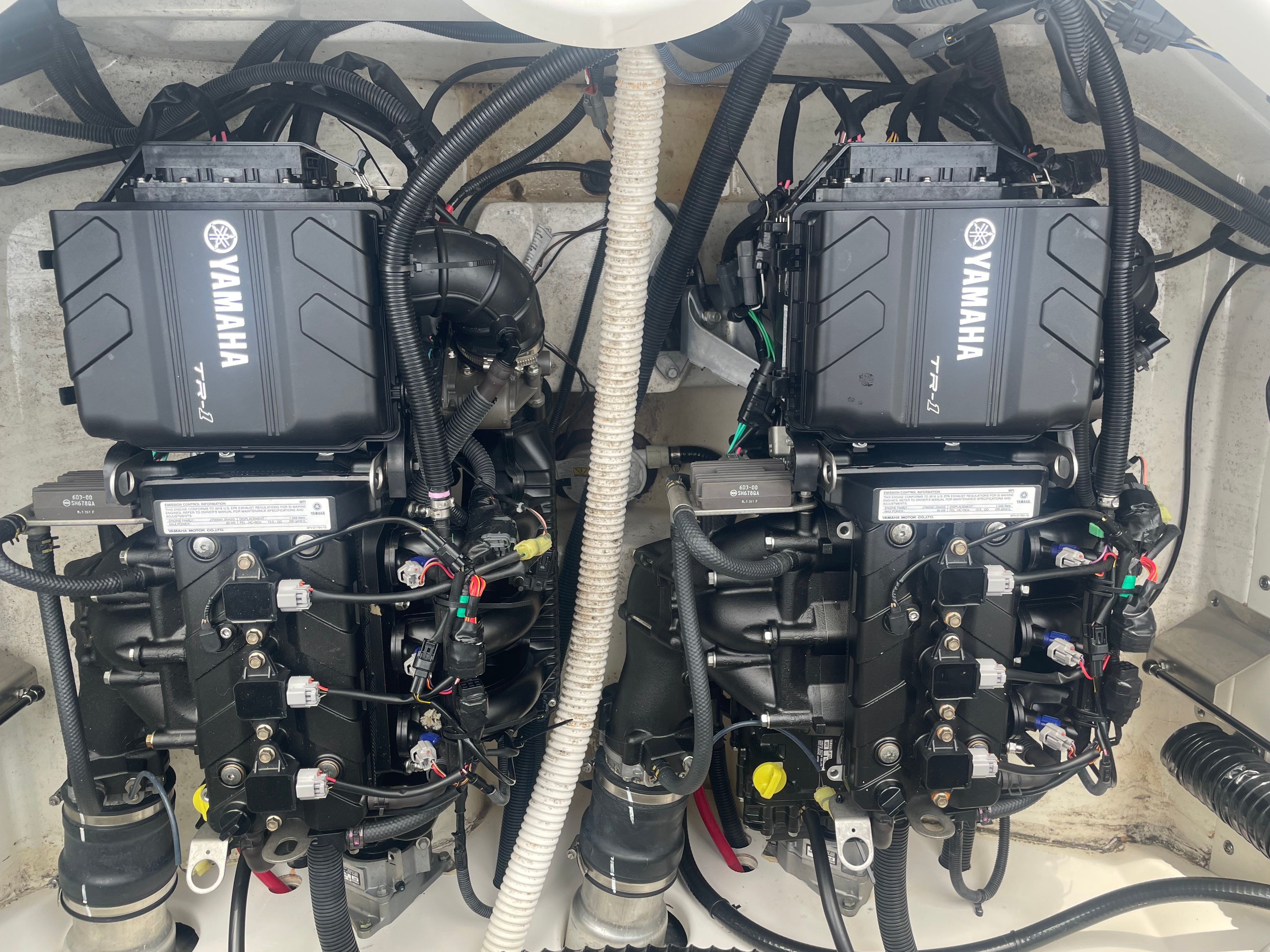 Two Yamaha engines inside a boat, surrounded by cables and hoses.