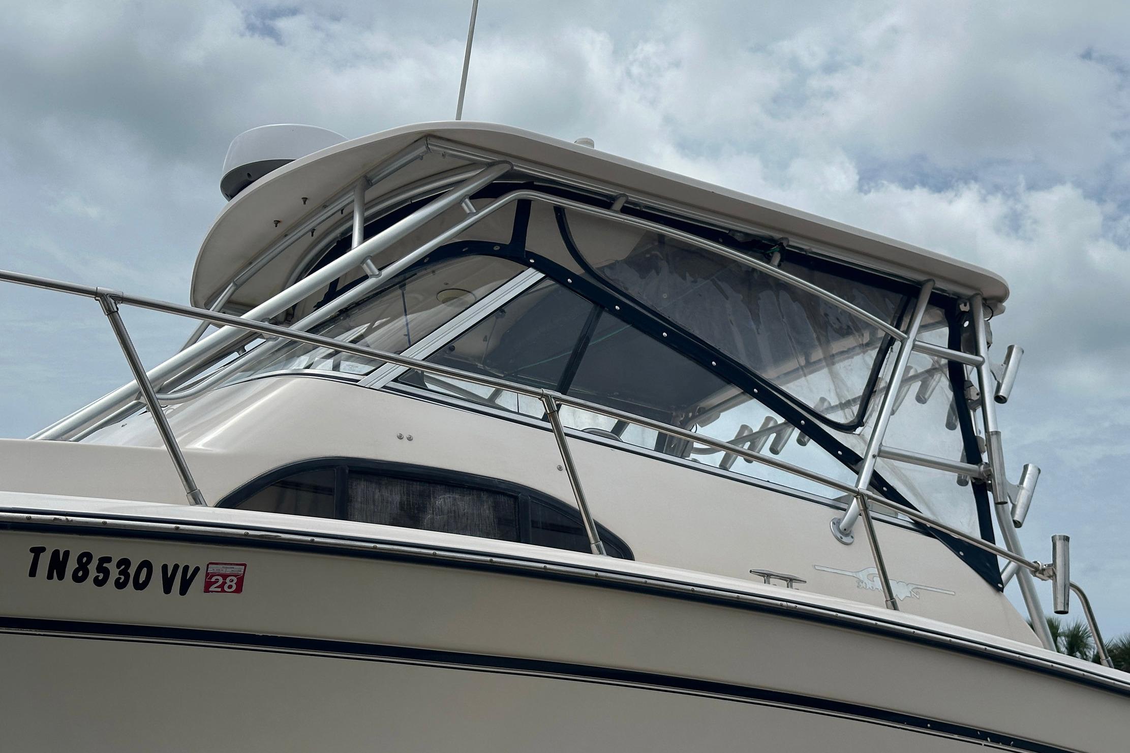 2006 Grady-White Marlin 300 boat with enclosed cabin and visible registration number.