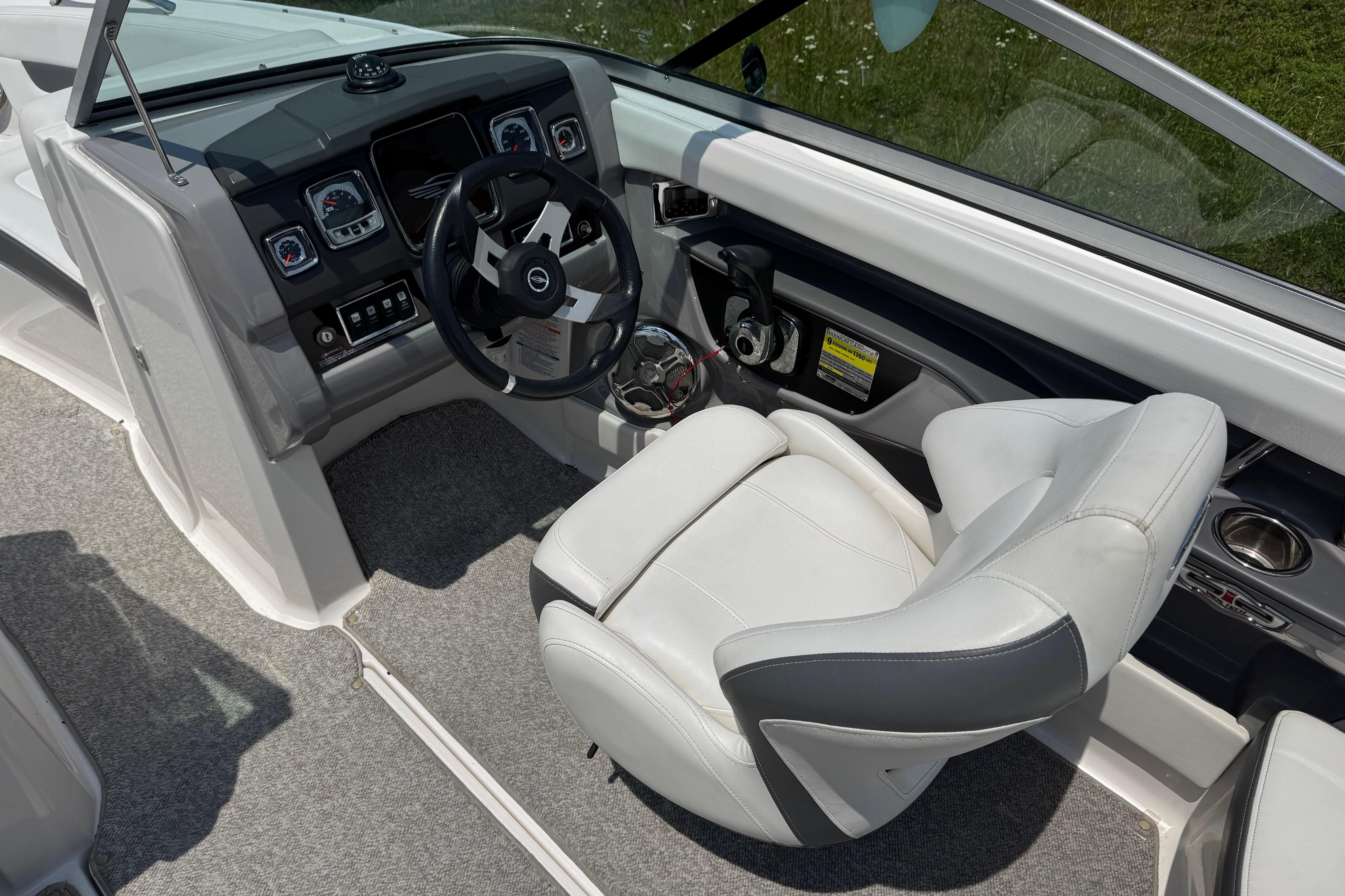 Interior of 2013 Chaparral 196 SSi boat featuring steering wheel and captain's seat.