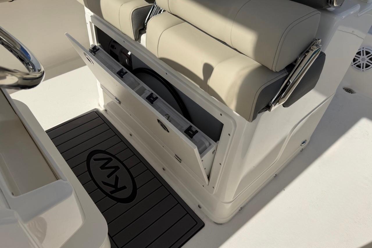 2026 Key West 239 FSR boat interior with storage compartment and cushioned seating.