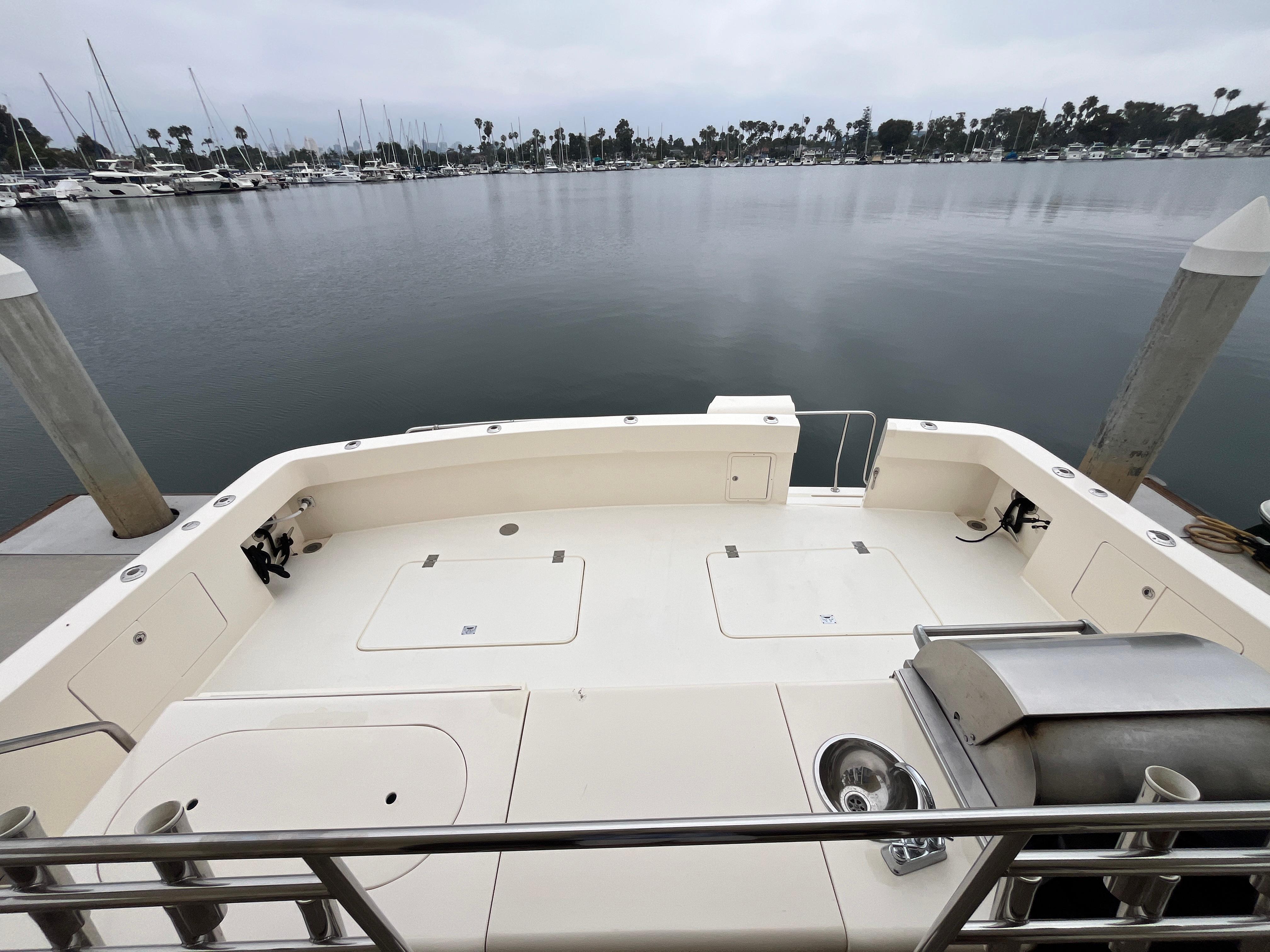 1999 Mikelson Long-Range Luxury Sportfisher docked, featuring spacious deck and marina view.