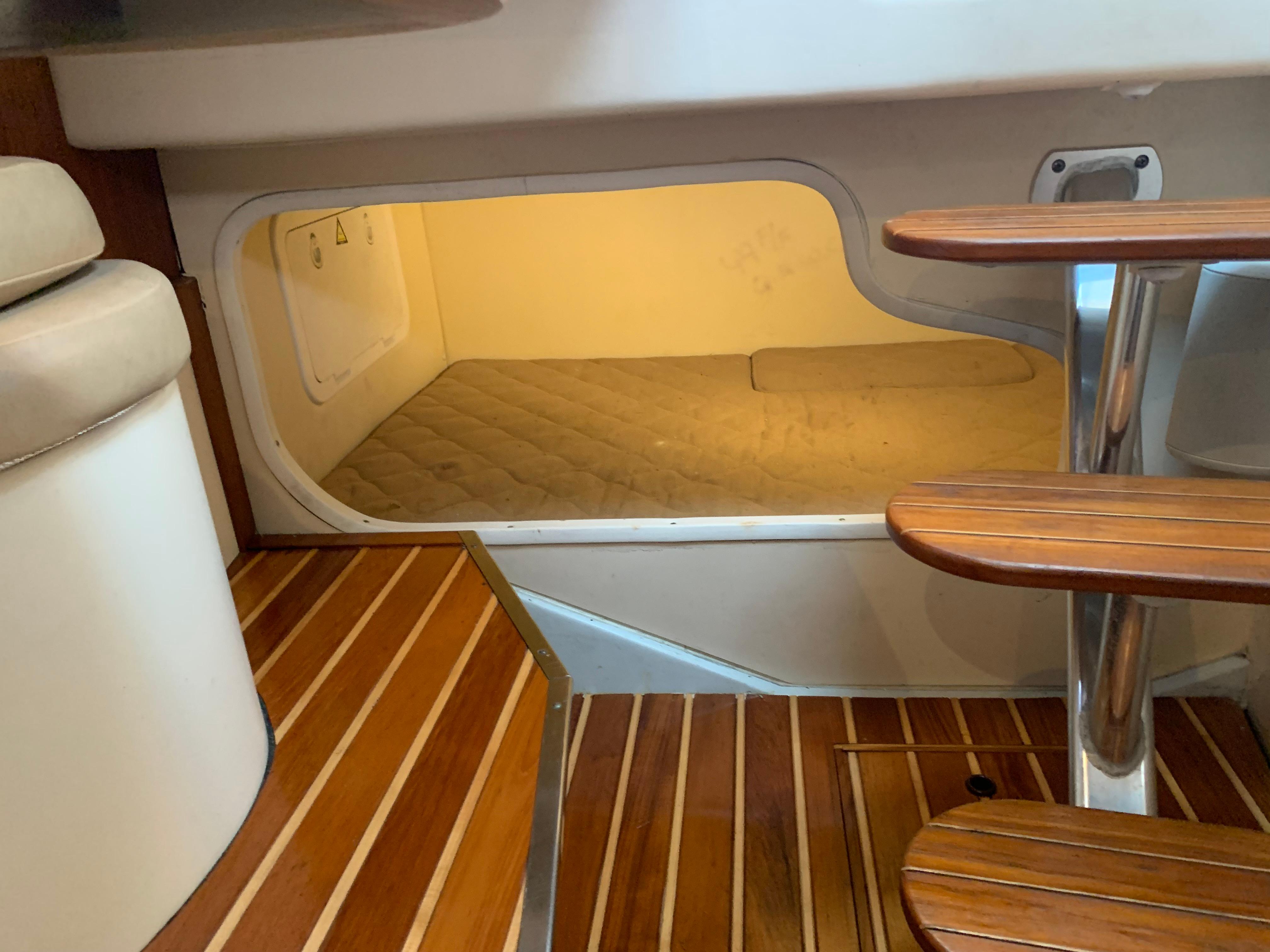 2007 Pursuit OS 335 cabin interior with wooden steps and cozy sleeping area.