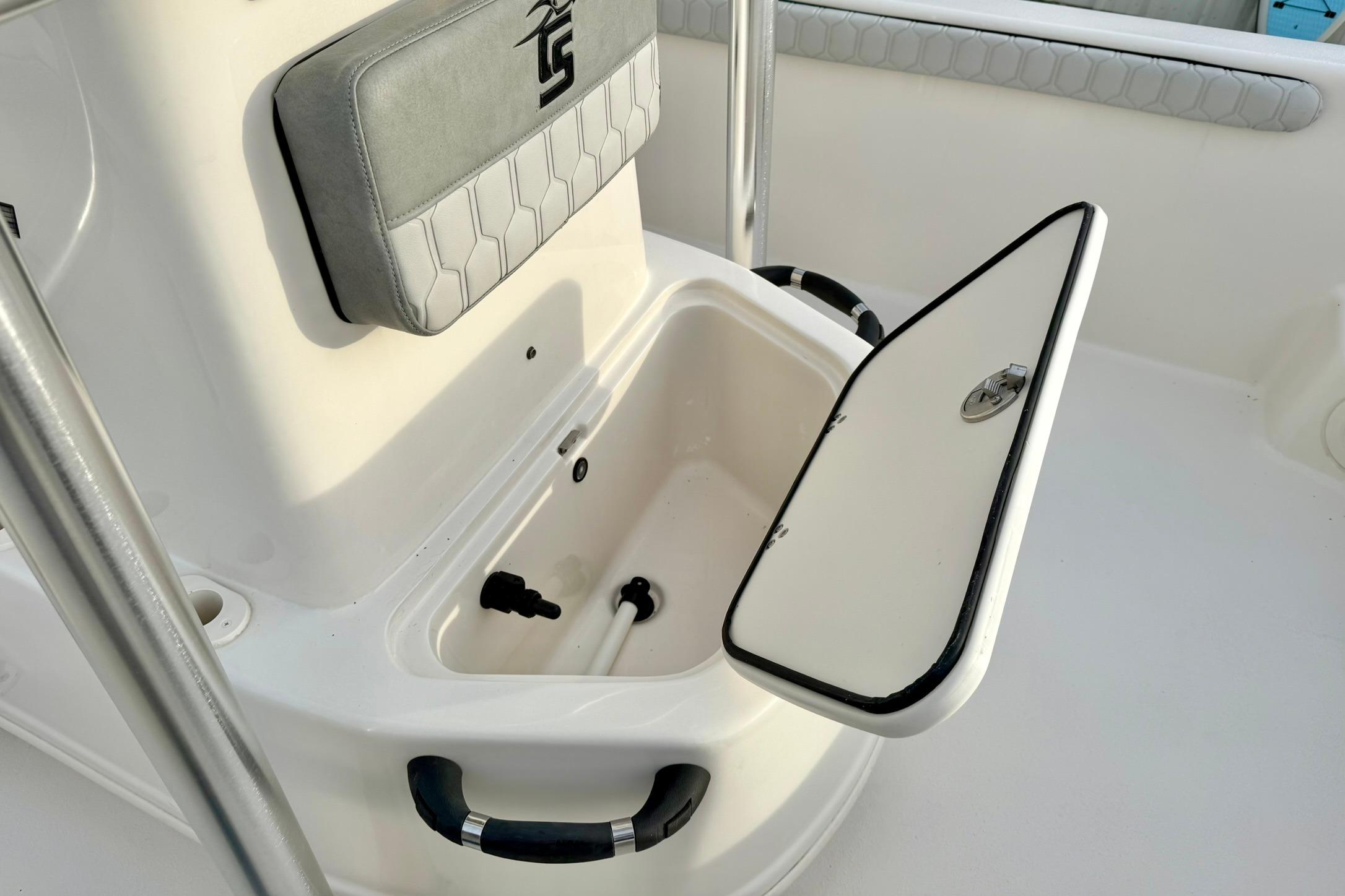 2025 Carolina Skiff 21 LS boat interior with open storage compartment and cushioned seat.