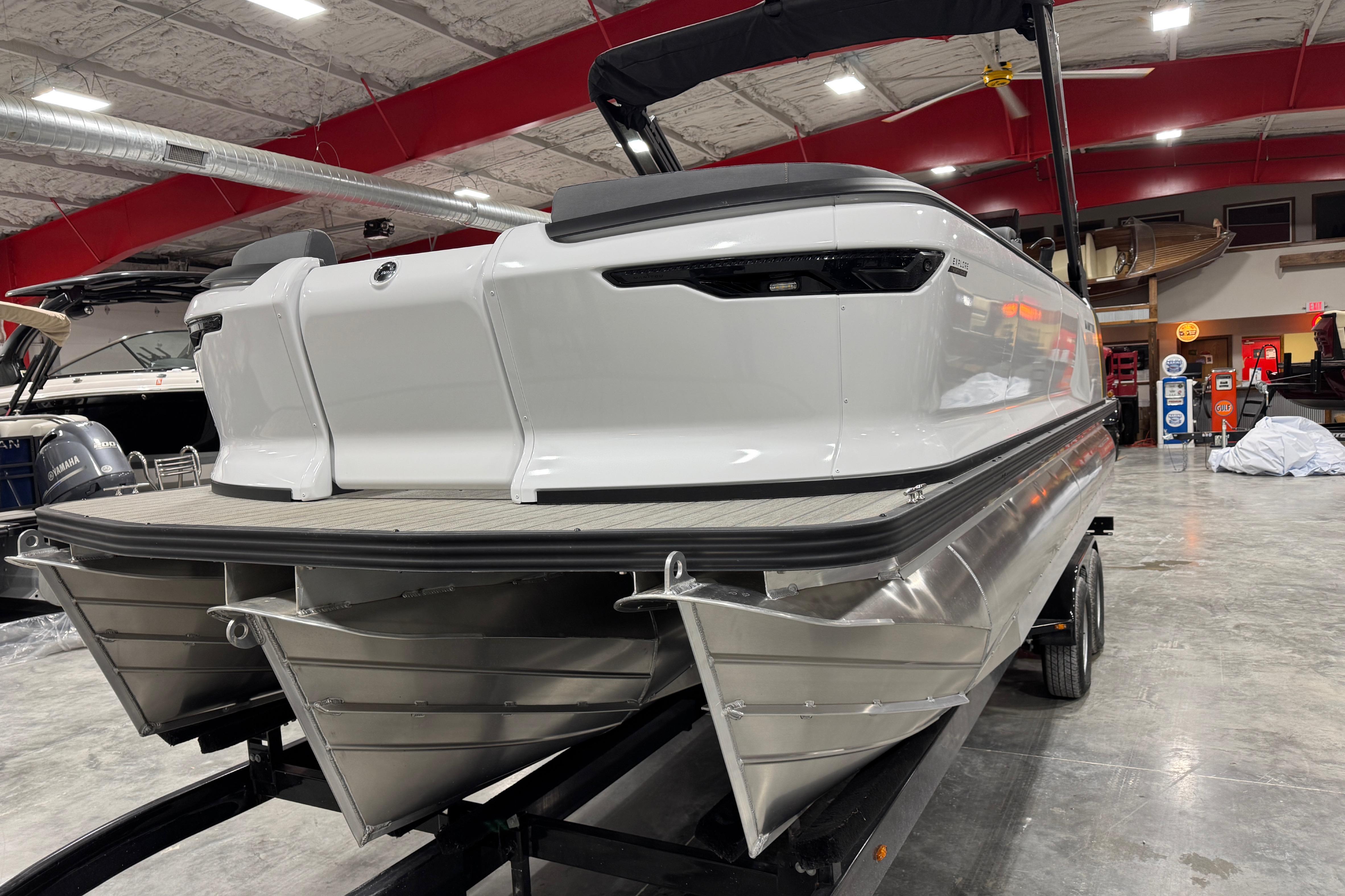 2025 Manitou 24 Explore pontoon boat in showroom, rear view.