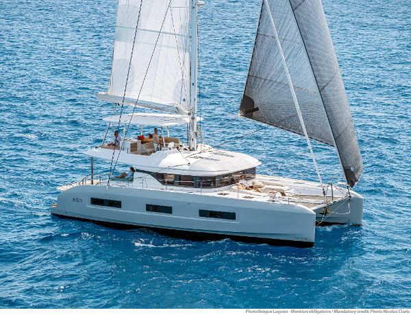 2025 Lagoon 55 catamaran sailing on clear blue ocean waters.