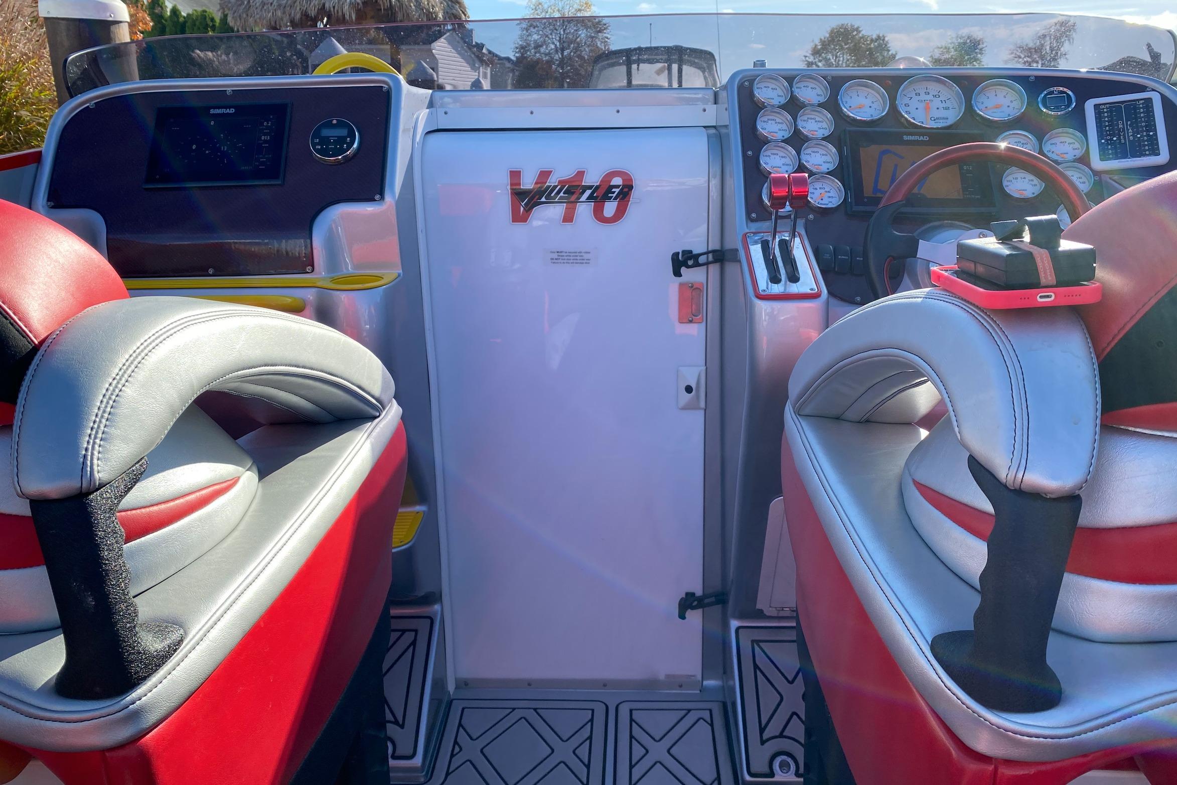 Interior of a 2005 Hustler 388 SLINGSHOT boat with red and gray seating.