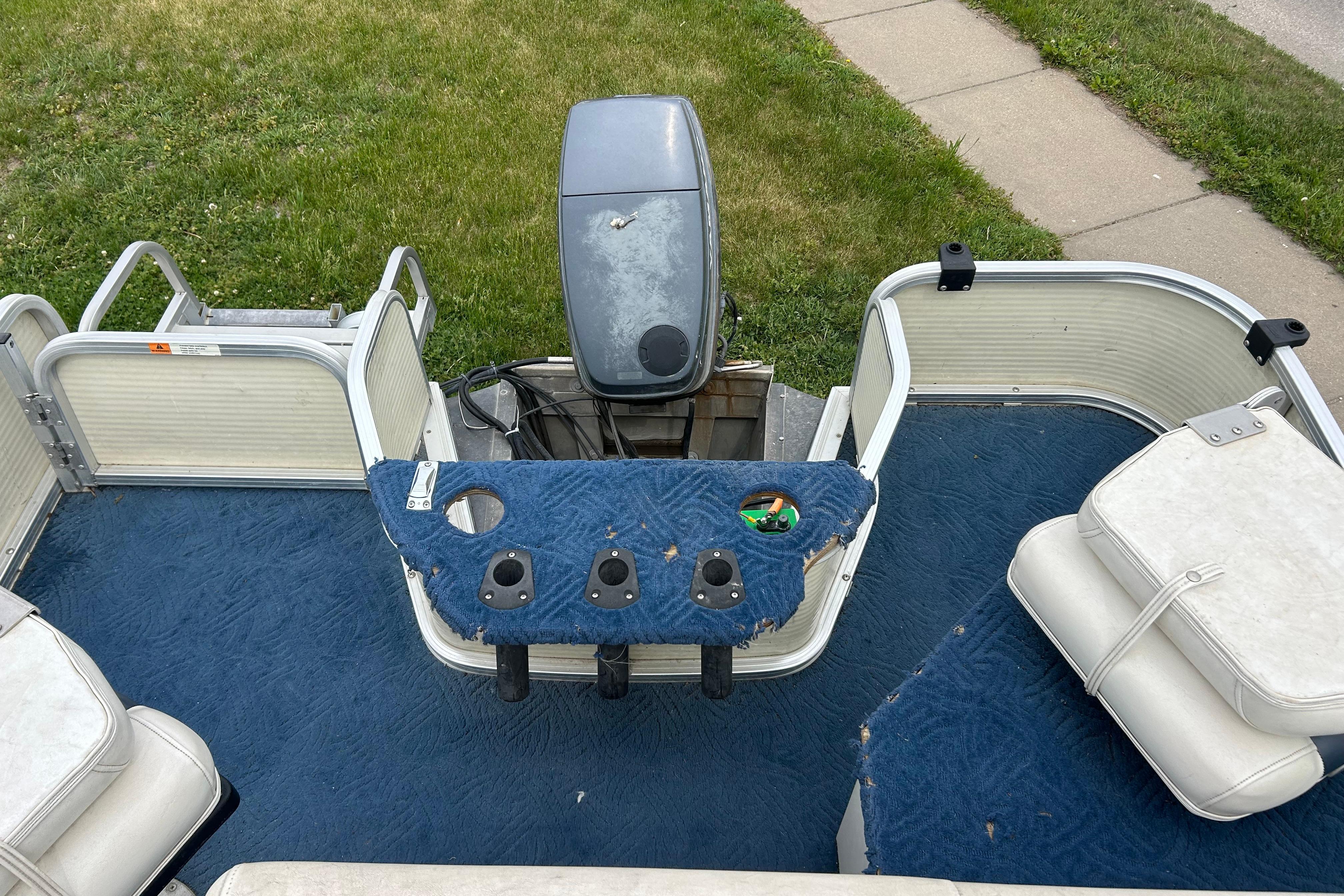 2002 Lowe Trinidad 200 pontoon boat interior with blue carpet and seating.