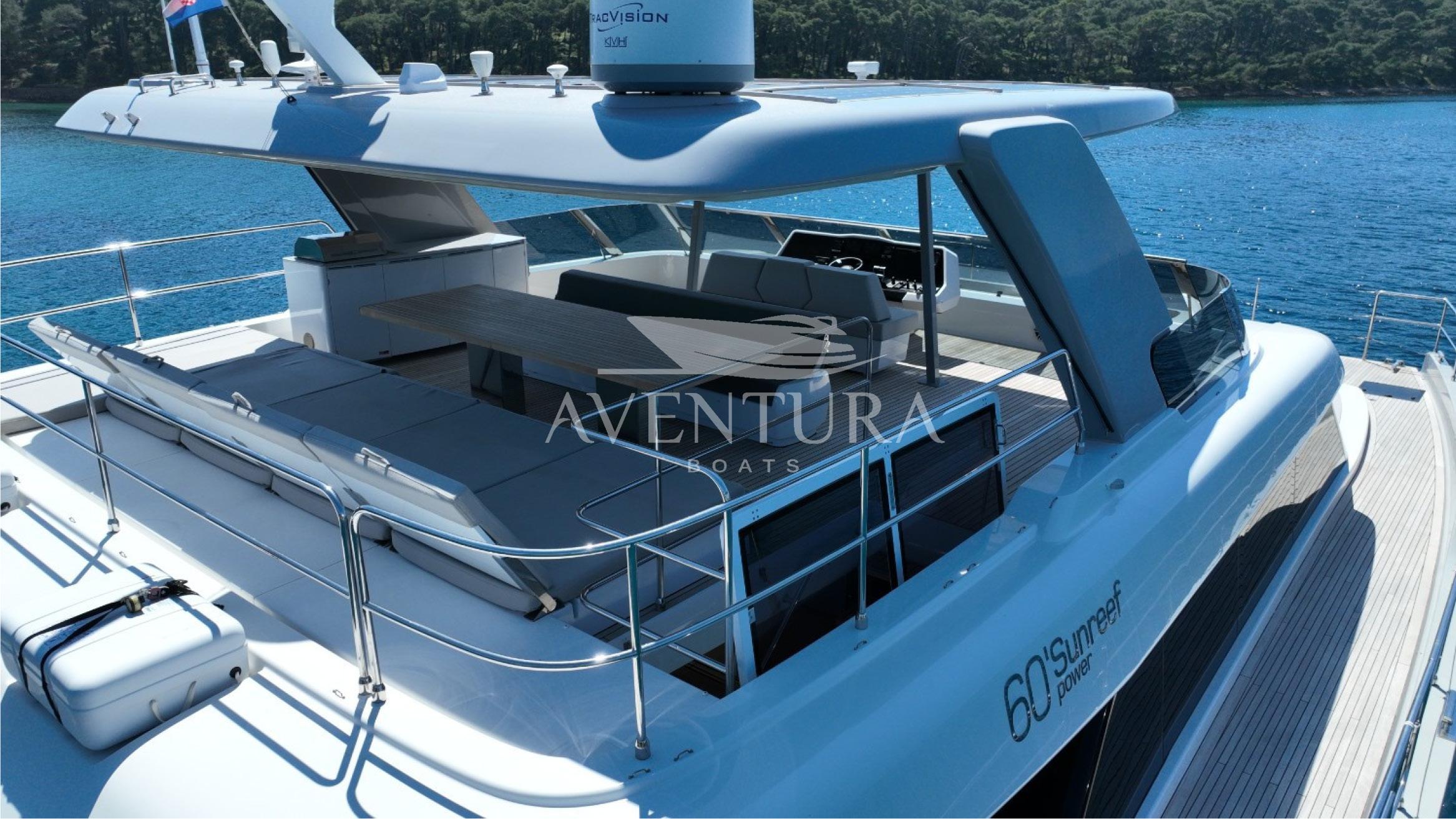 Sunreef 60 Power yacht, 2021 model, featuring spacious deck and modern design on serene water.