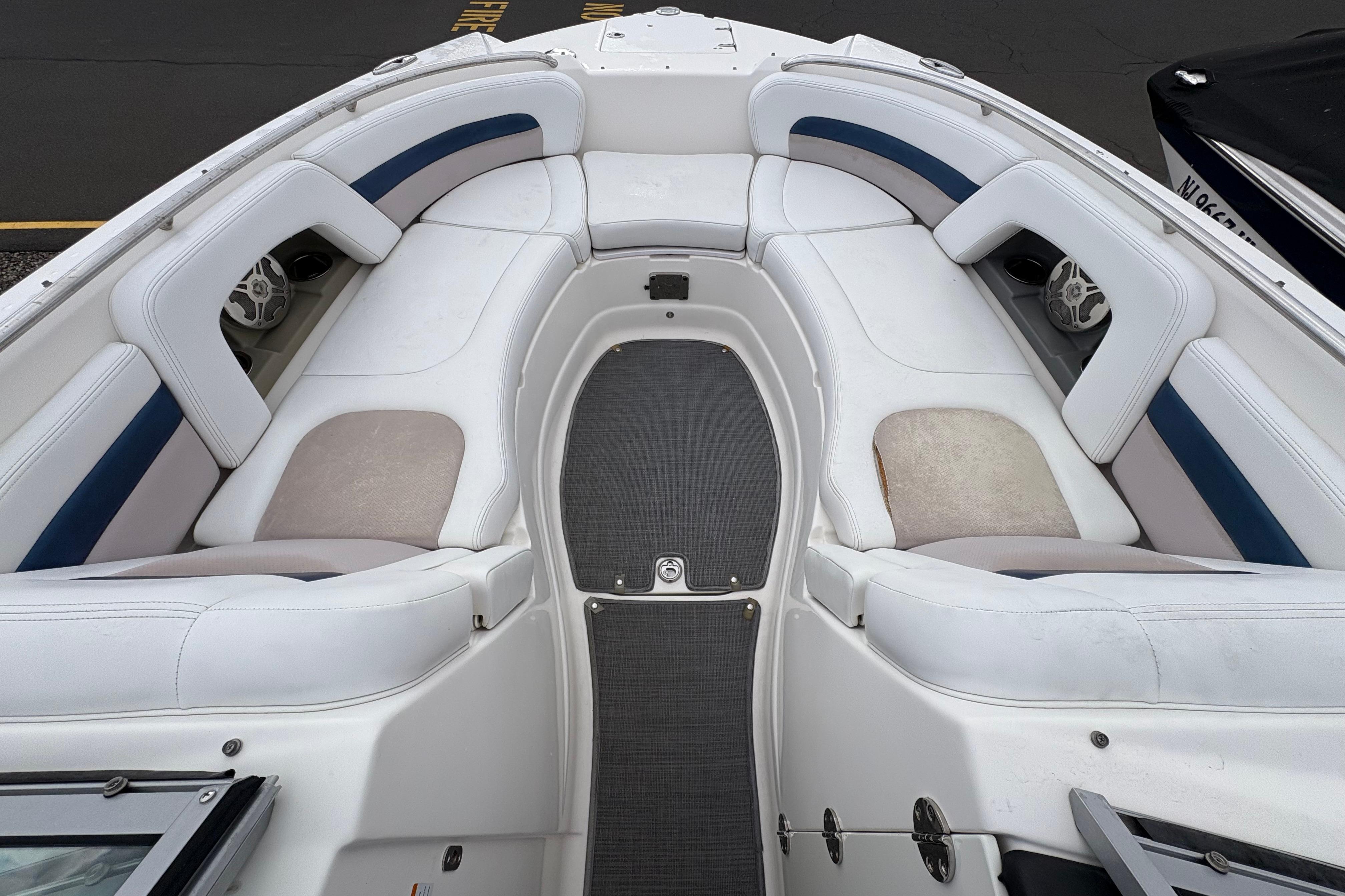 2015 Chaparral 264 Sunesta boat interior with white cushioned seating and gray flooring.