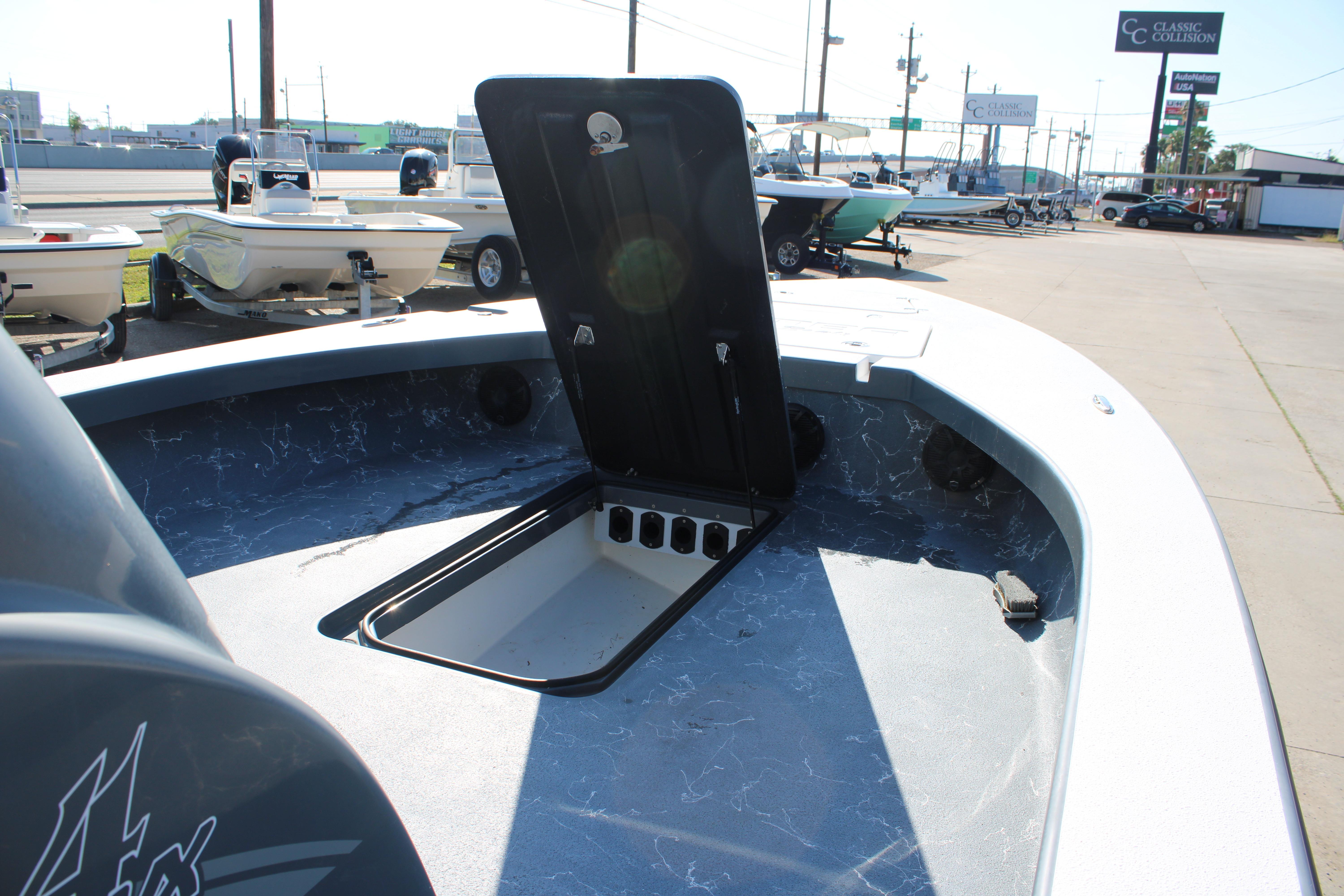 2023 Mamba 24VX boat with open storage compartment, displayed in a dealership lot.