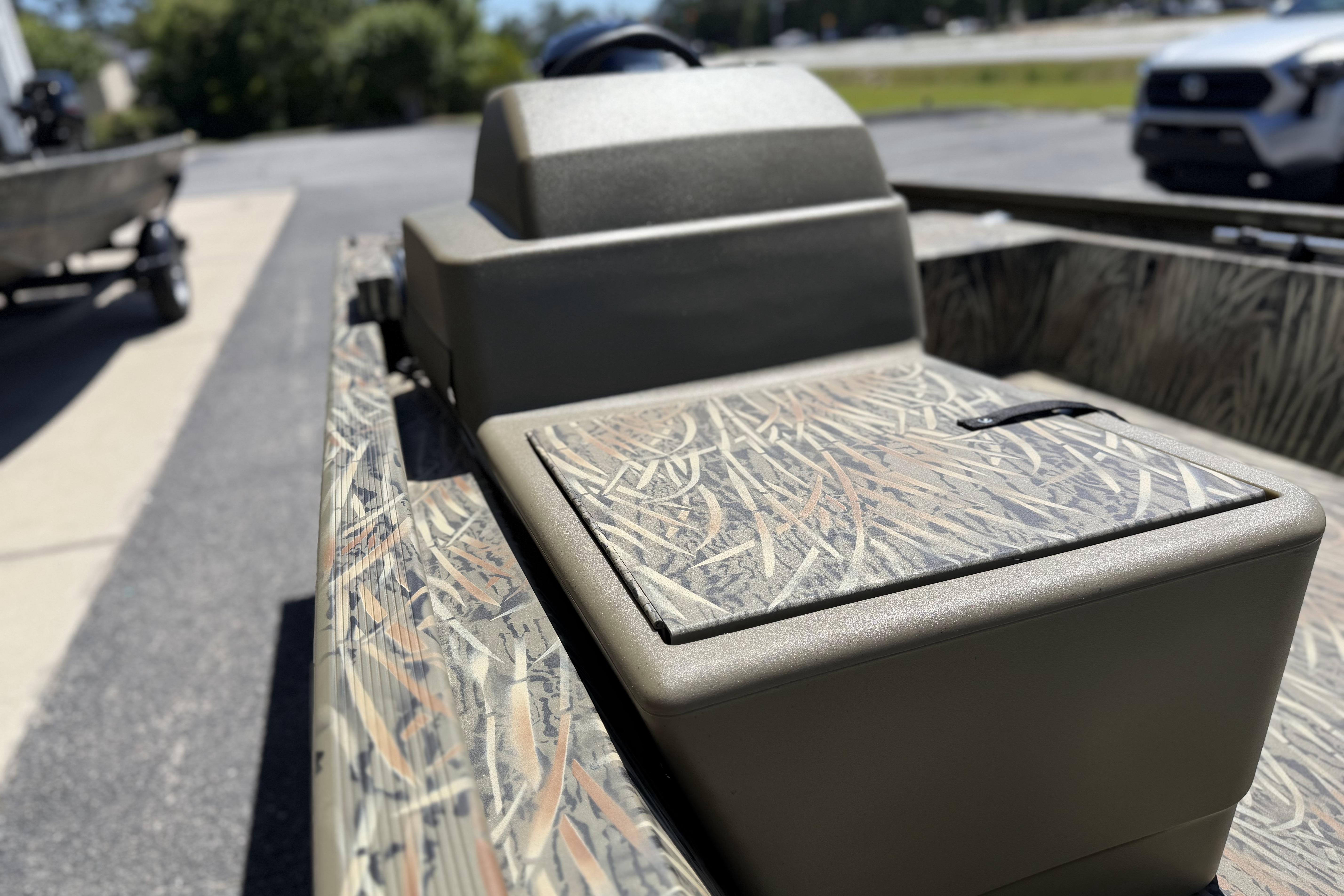 2026 Tracker Grizzly 1648 SC boat with camouflage design, parked outdoors.