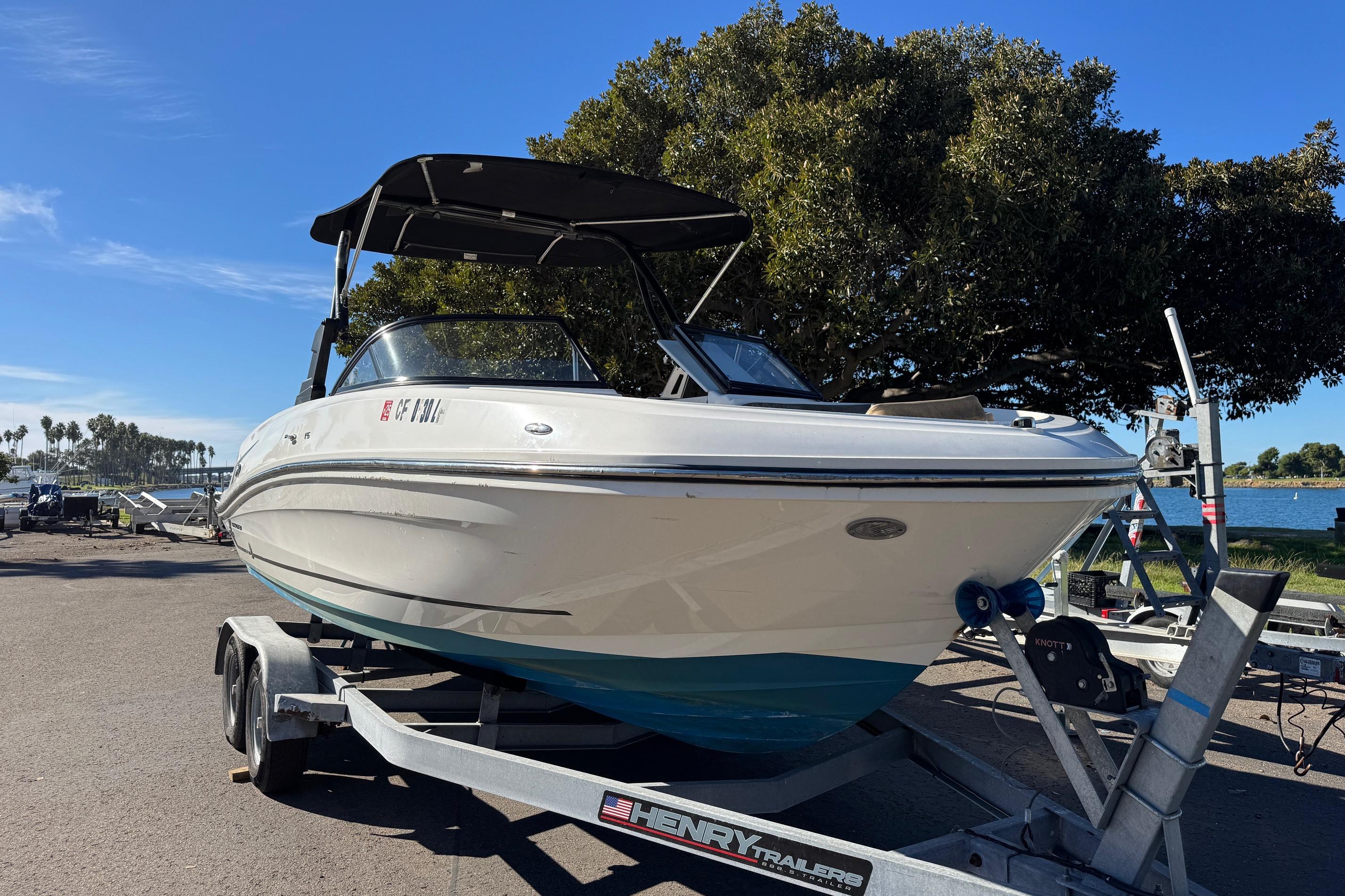 2022 Bayliner VR6 Bowrider OB on trailer, parked near waterfront under clear blue sky.