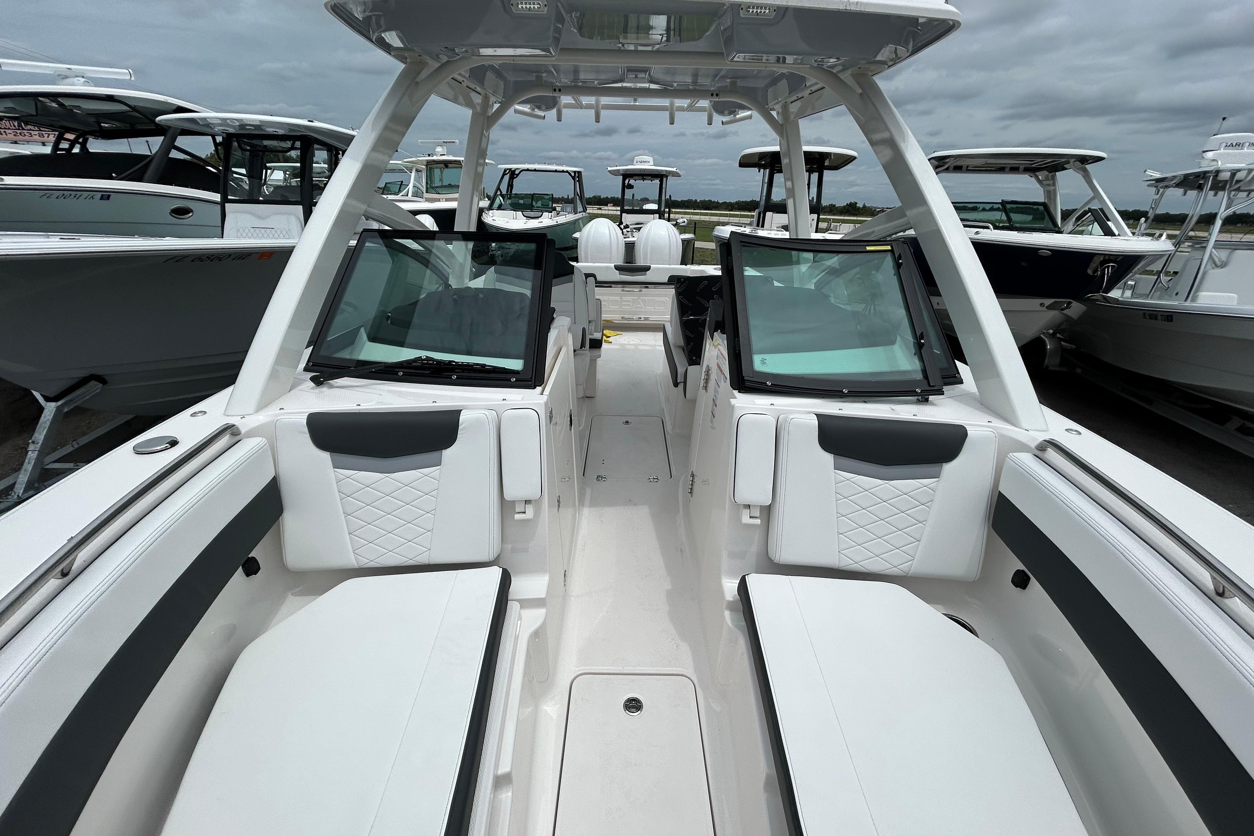 2026 Robalo R277 Dual Console boat interior with seating and windshield, docked among other boats.