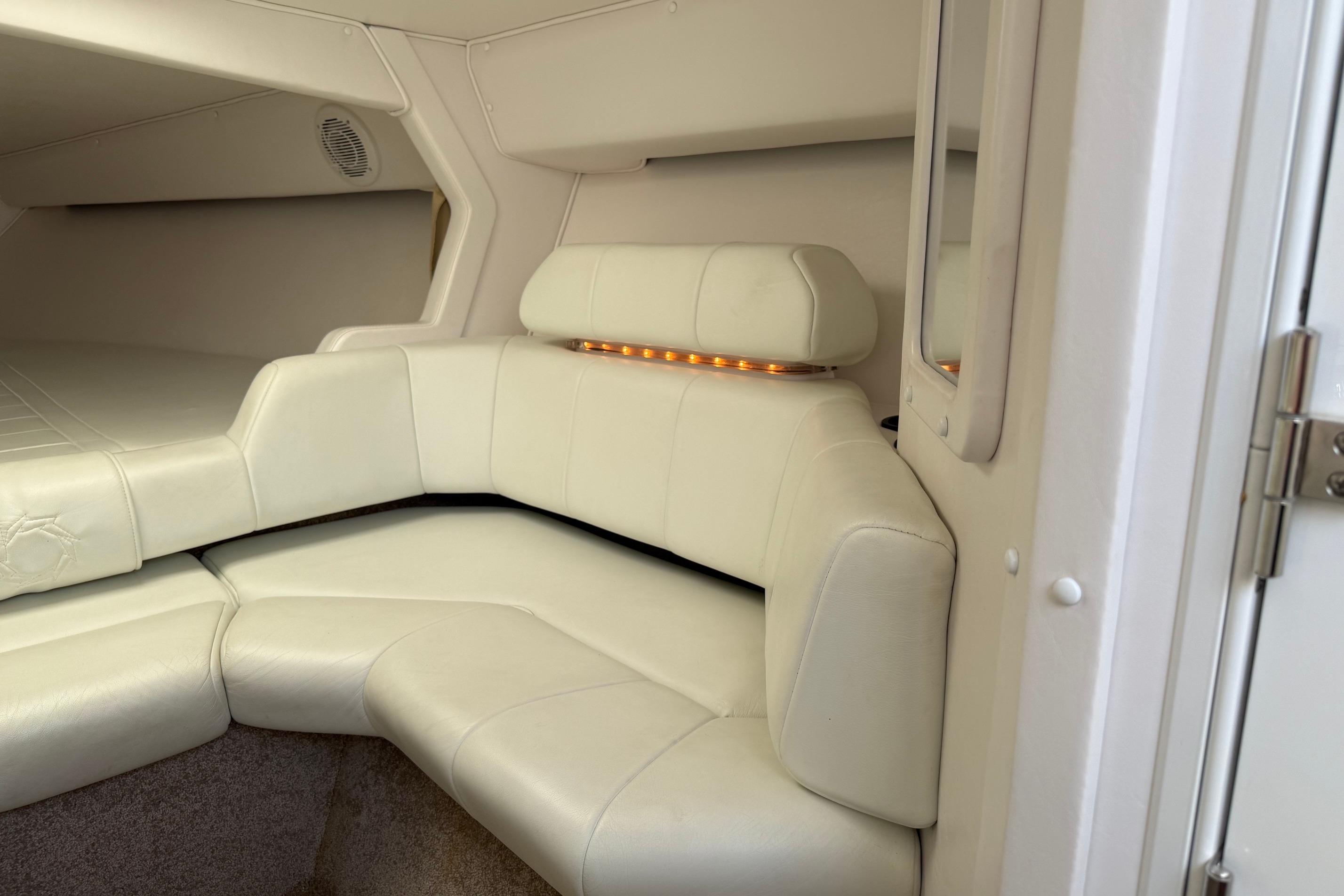 Interior of 1998 Fountain 35 Lightning boat with white leather seating and ambient lighting.