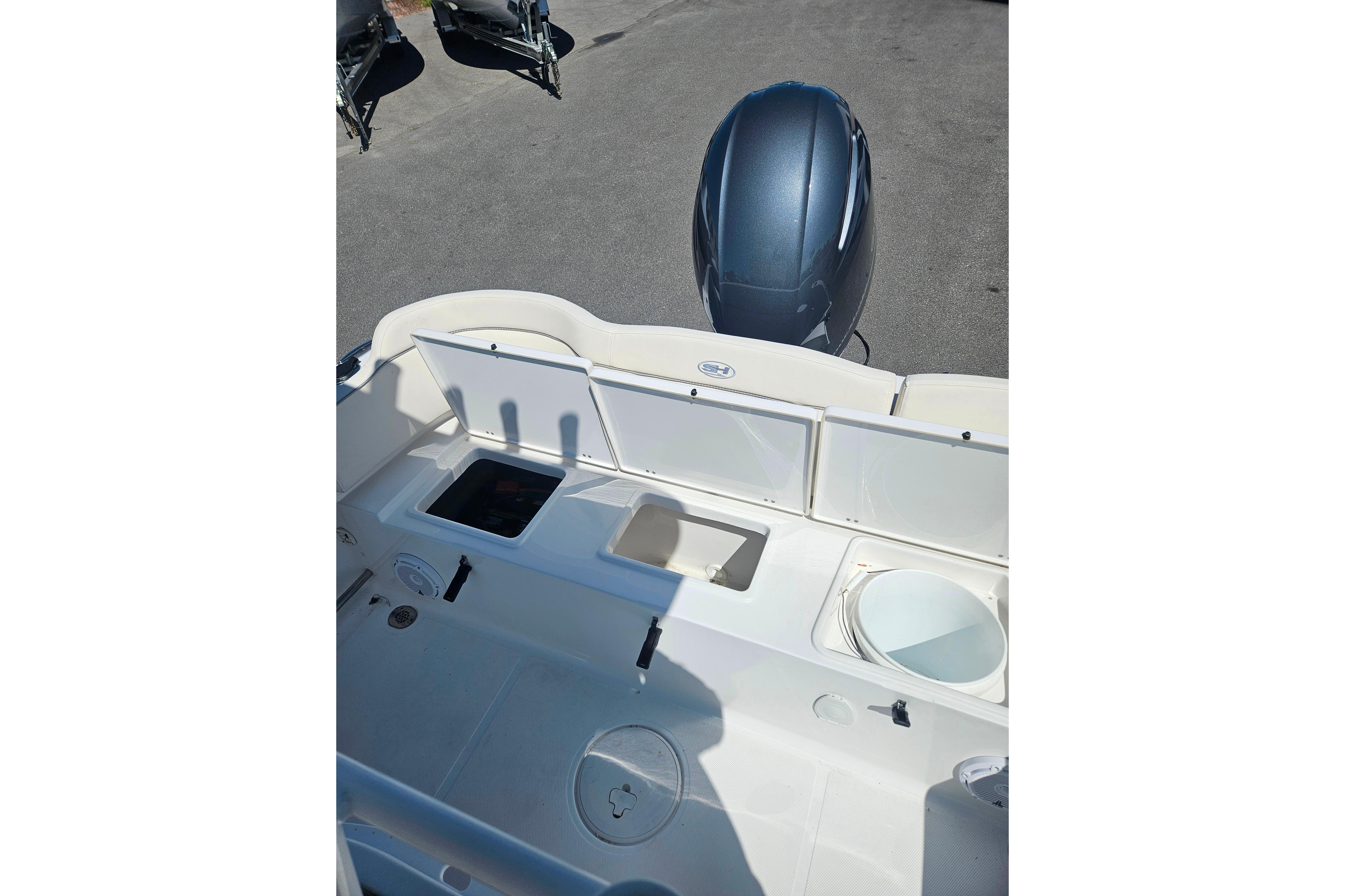2023 Sea Hunt Ultra 229 boat interior with storage compartments and engine view.