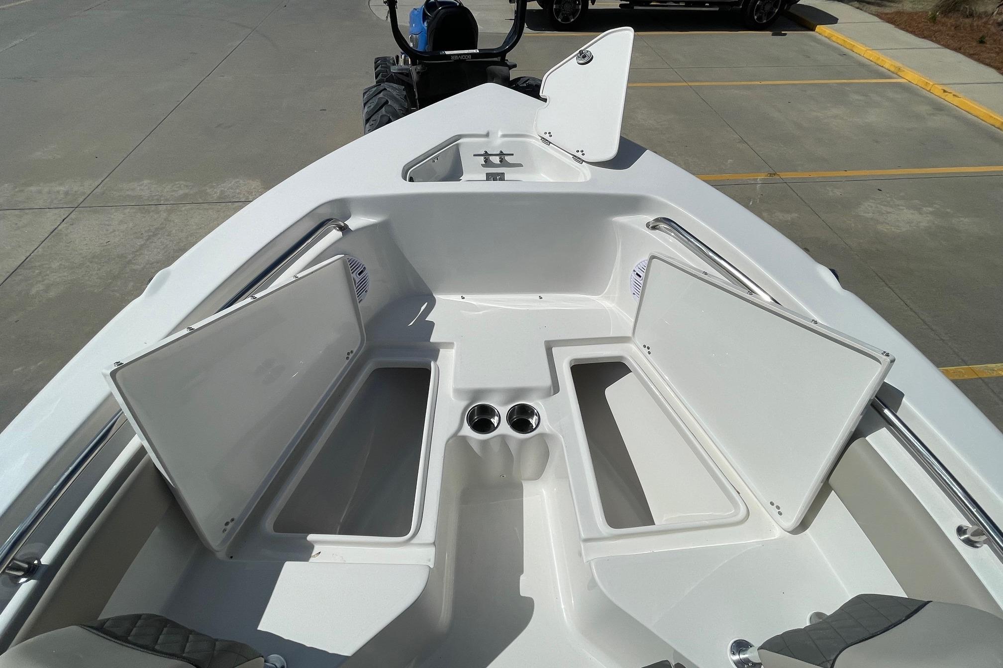 2026 Key West 203 FS boat interior with open storage compartments and cup holders.