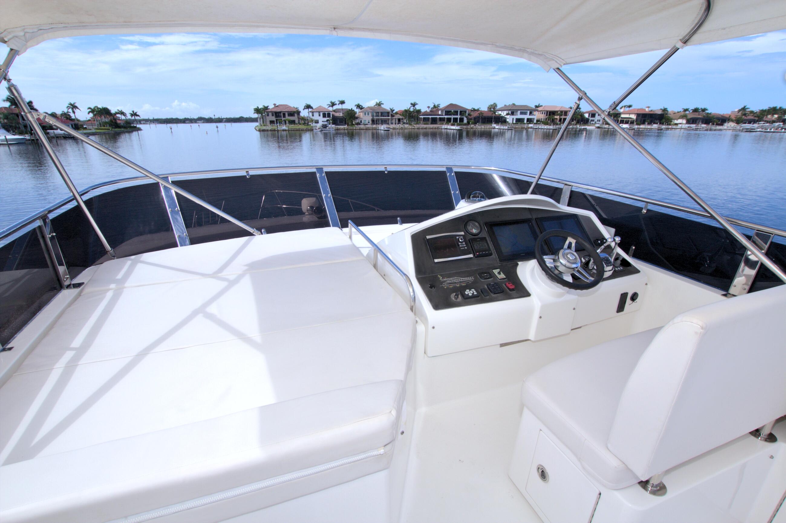 Helm of 2015 Dyna 60 yacht with scenic waterfront view.