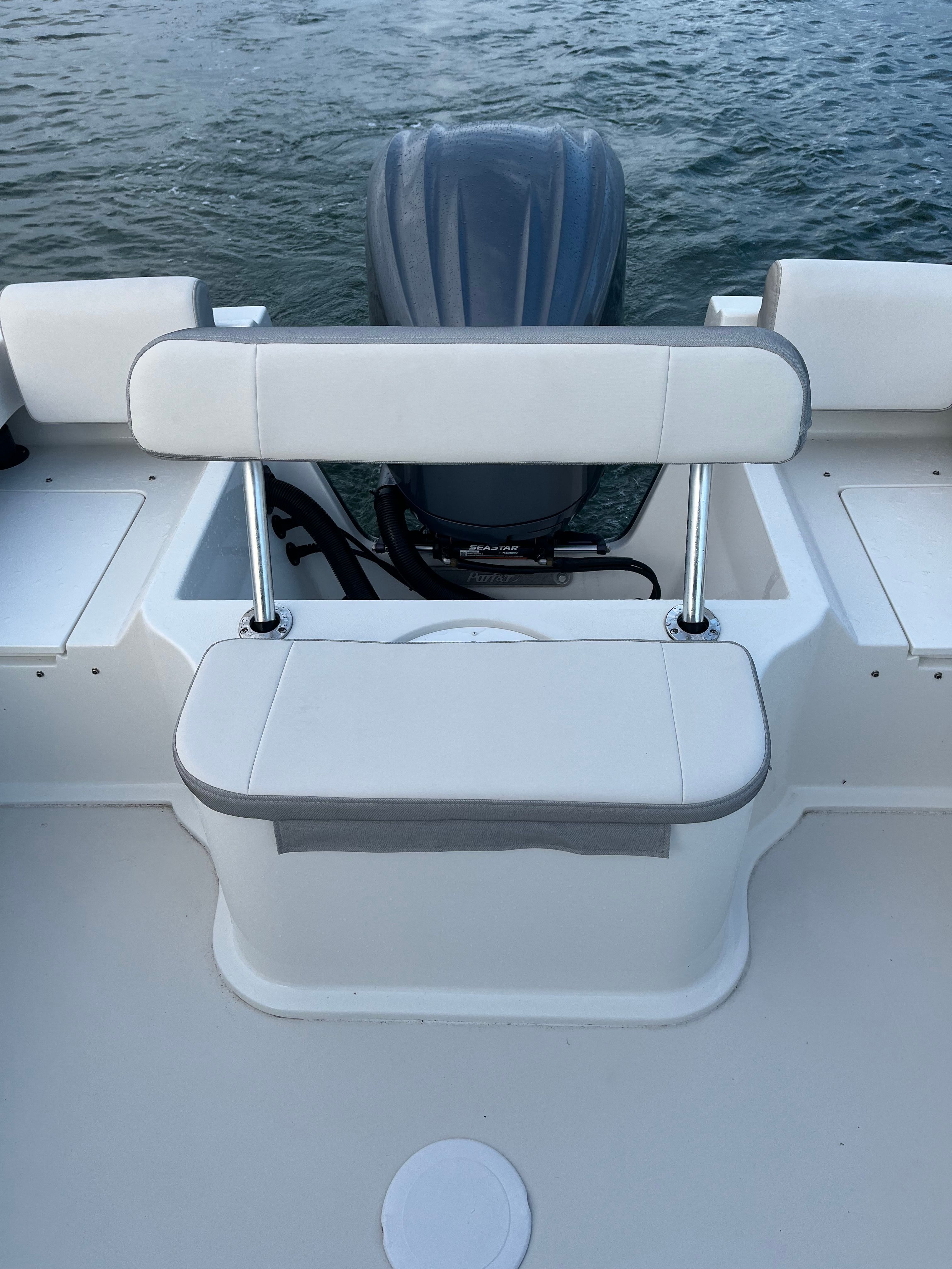 Rear view of a Parker 2021 sport cabin boat with outboard motor and bench seat.