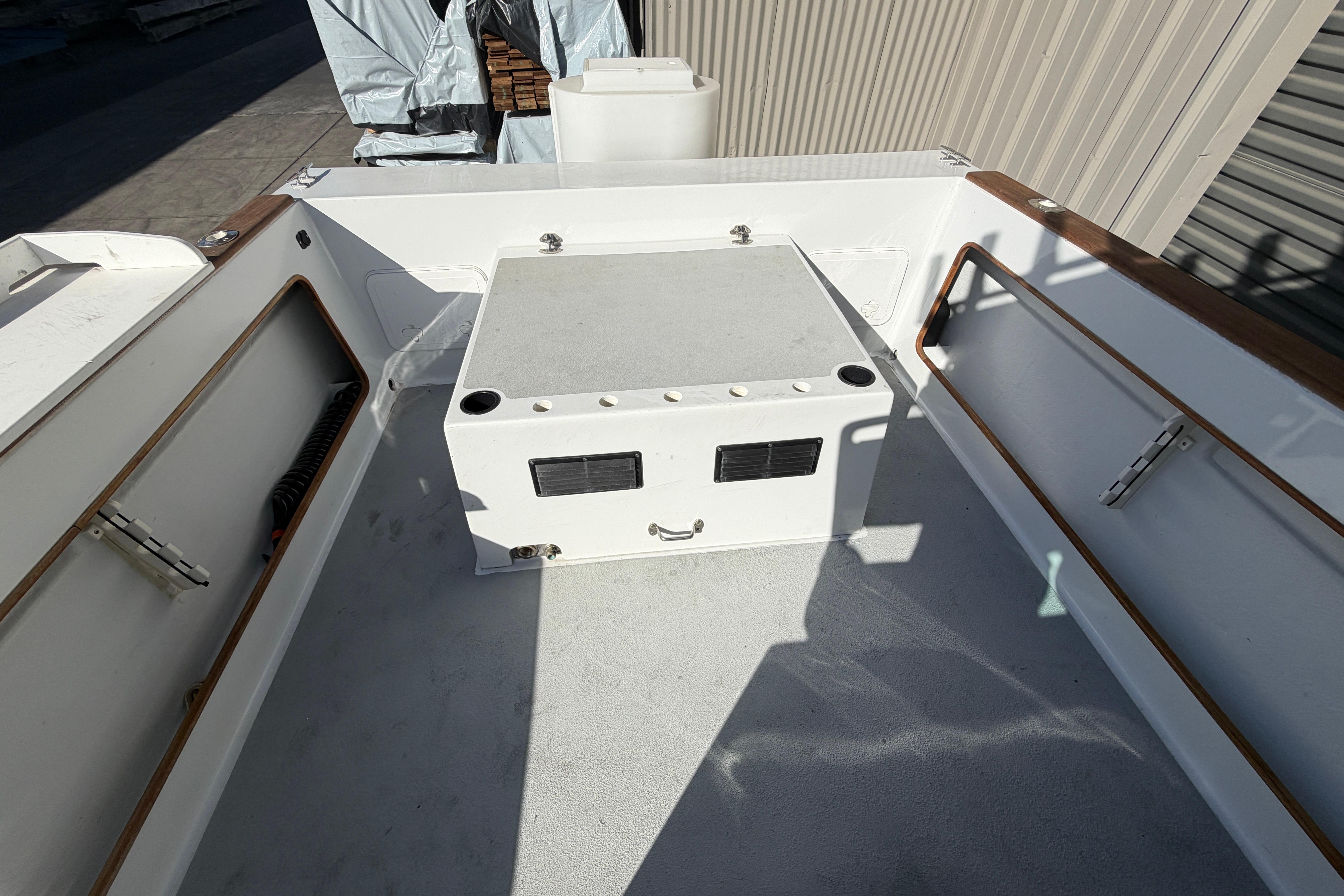 1986 Radon 21 Sport boat deck with storage compartment and wooden railings.