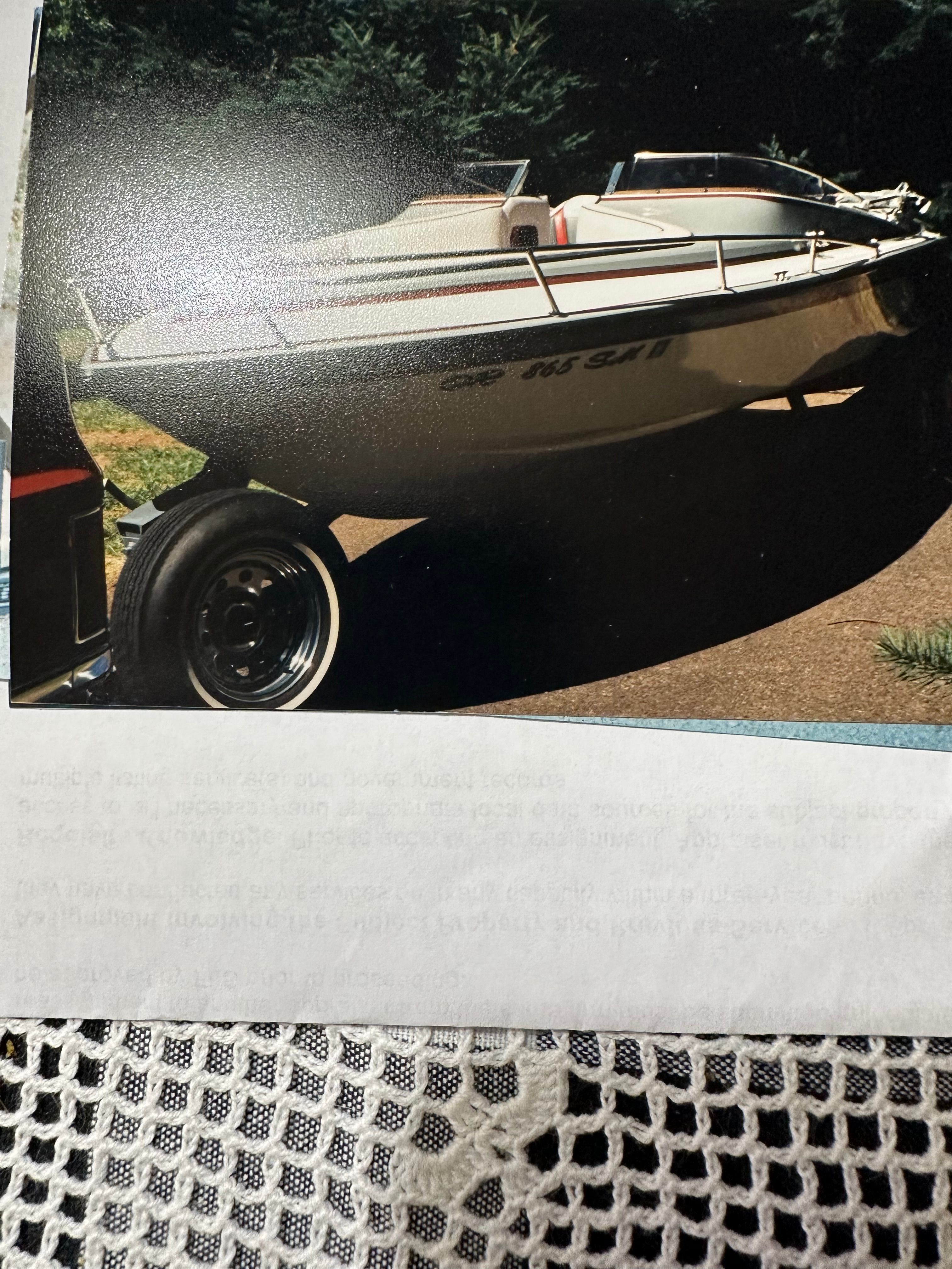 A 1990 Marlin Open Bow boat on a trailer, surrounded by trees.