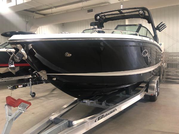 2024 Chaparral 28 Surf boat on trailer in indoor showroom.