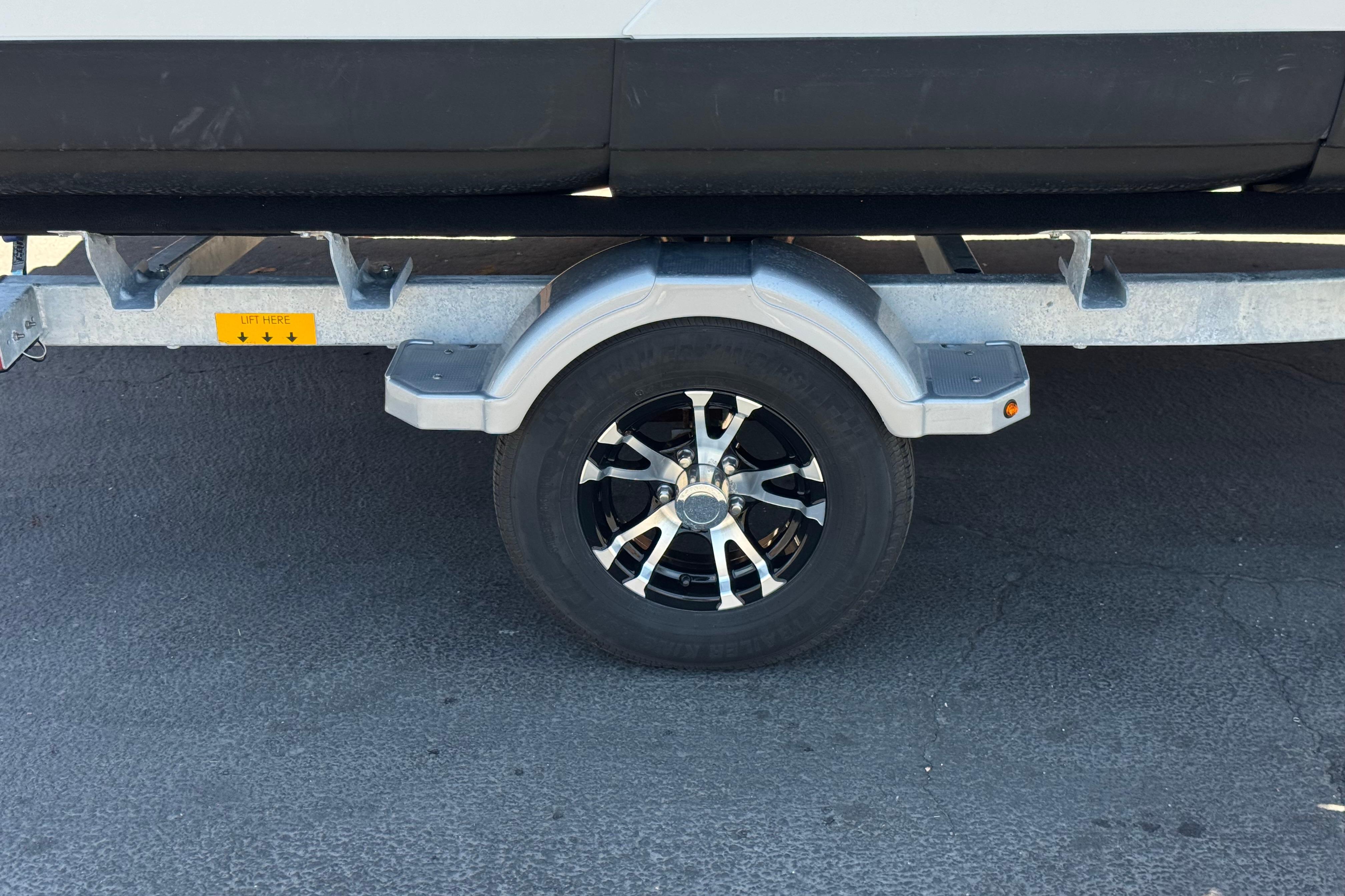 Trailer wheel of 2024 Sea-Doo Switch Compact on pavement.