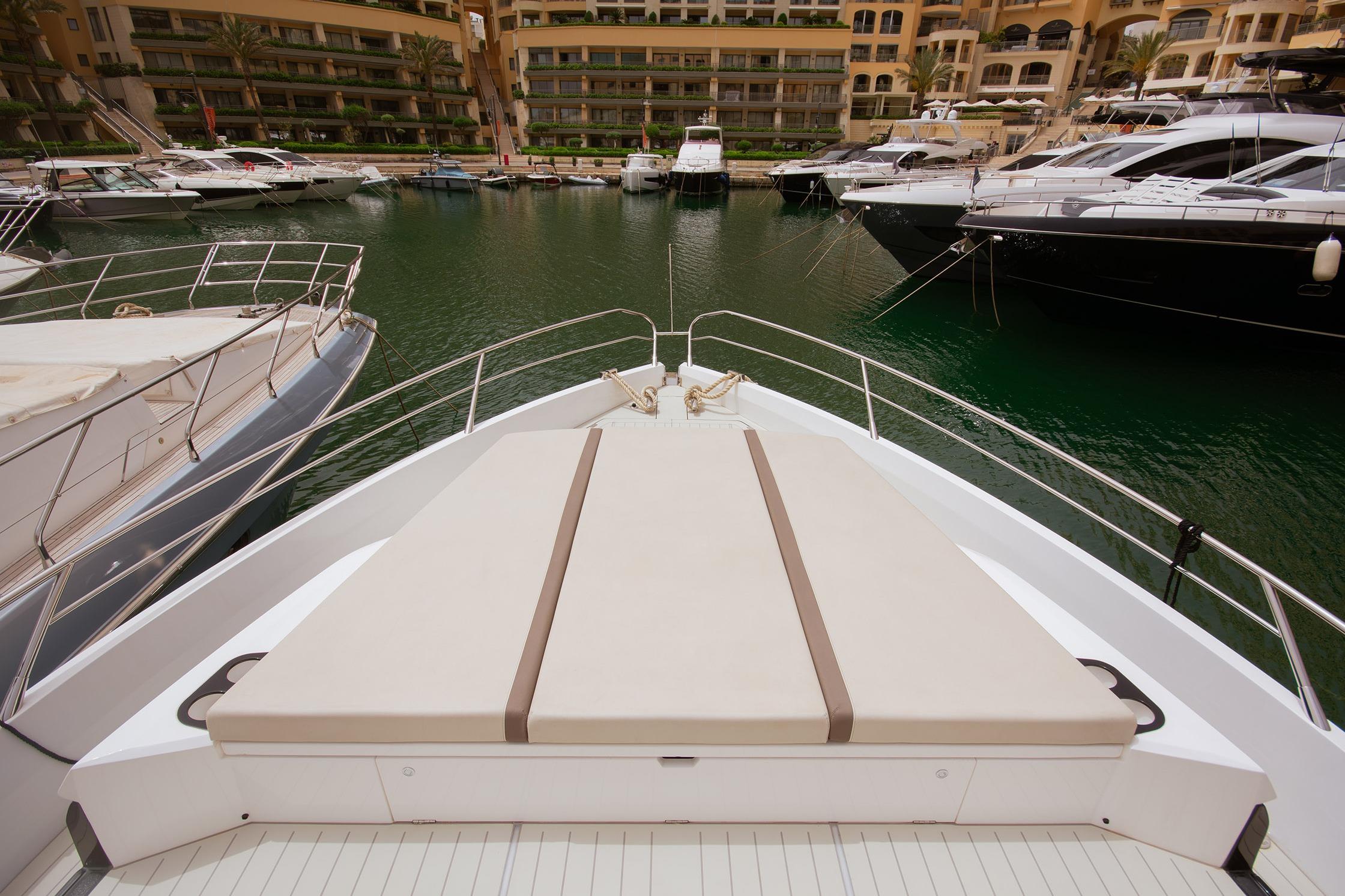2024 Sunseeker Superhawk 55 yacht docked in a marina, showcasing luxurious deck space.