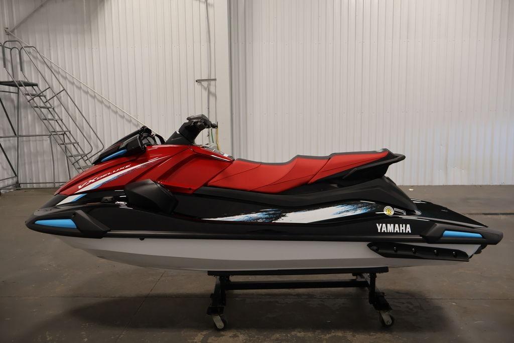 2026 Yamaha WaveRunner VX Deluxe in red and black, displayed indoors on a stand.