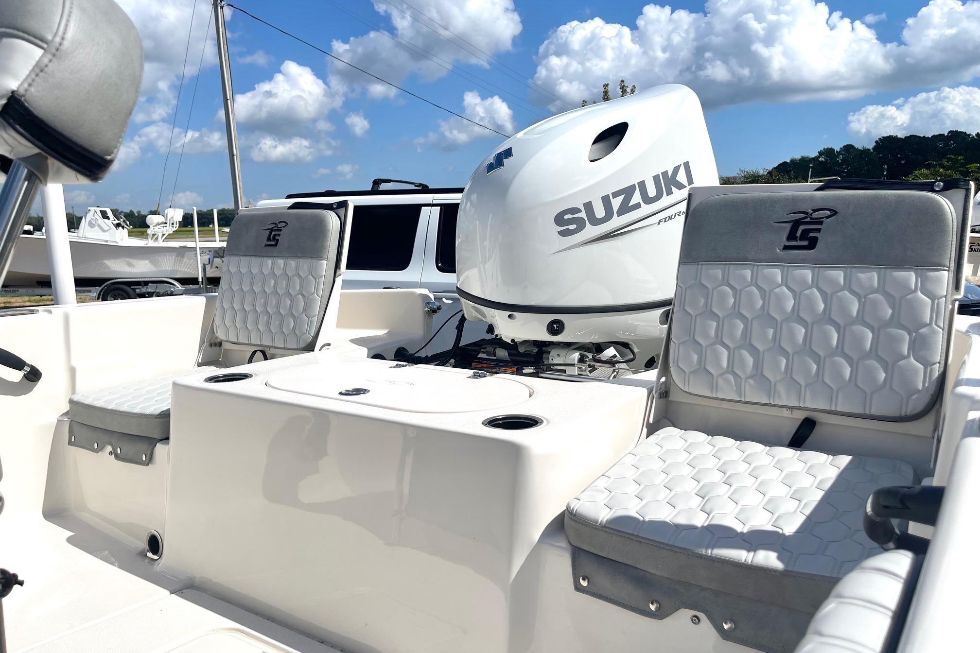 2026 Carolina Skiff 19 LS boat interior with Suzuki engine, featuring cushioned seating.
