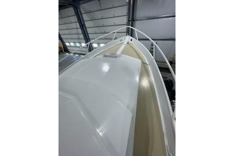 1964 Striker Model 120 boat in a garage, showcasing sleek white deck design.