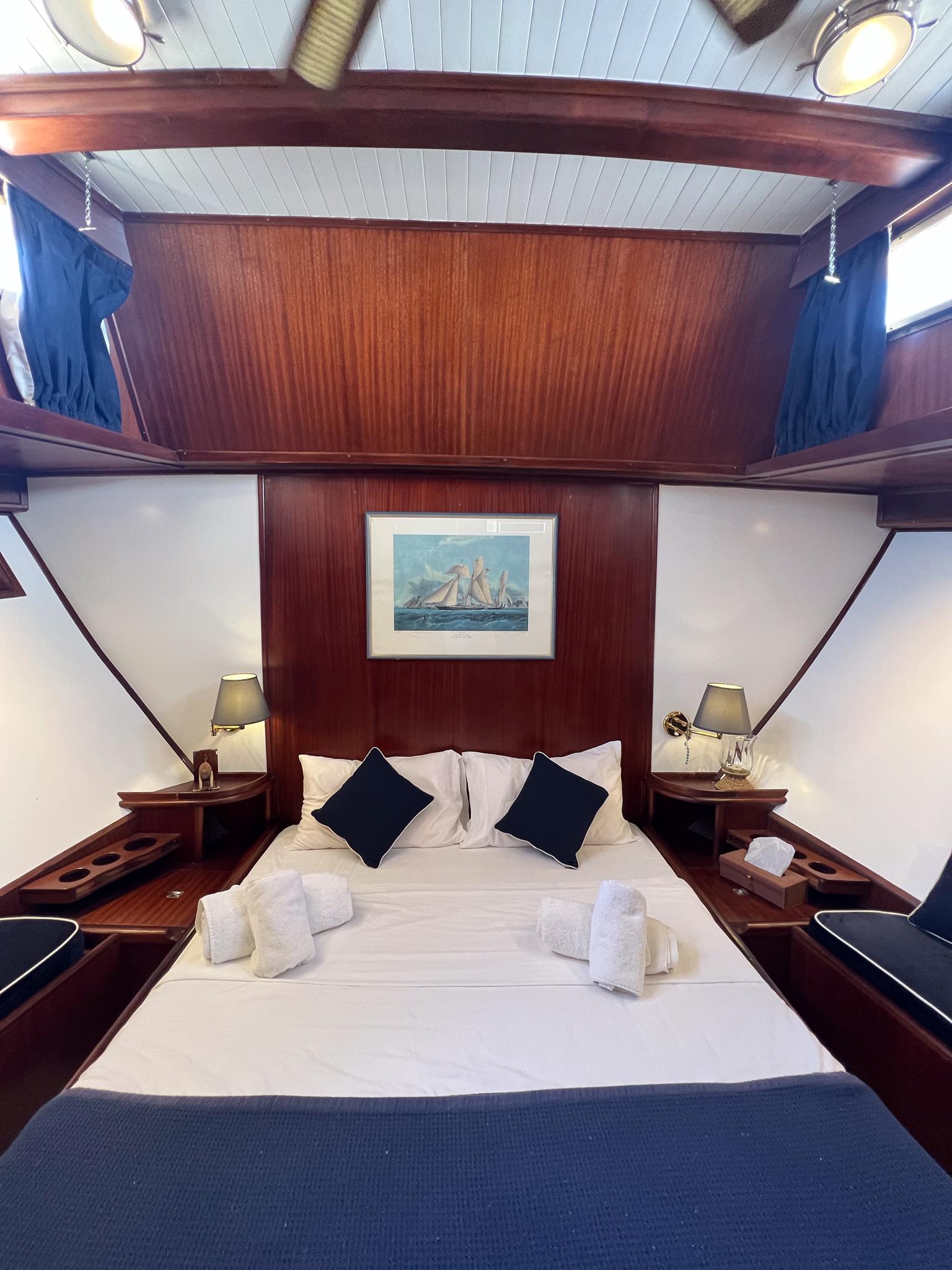 Luxurious cabin interior of 1969 Custom Psarros Shipyard yacht with elegant wood paneling.