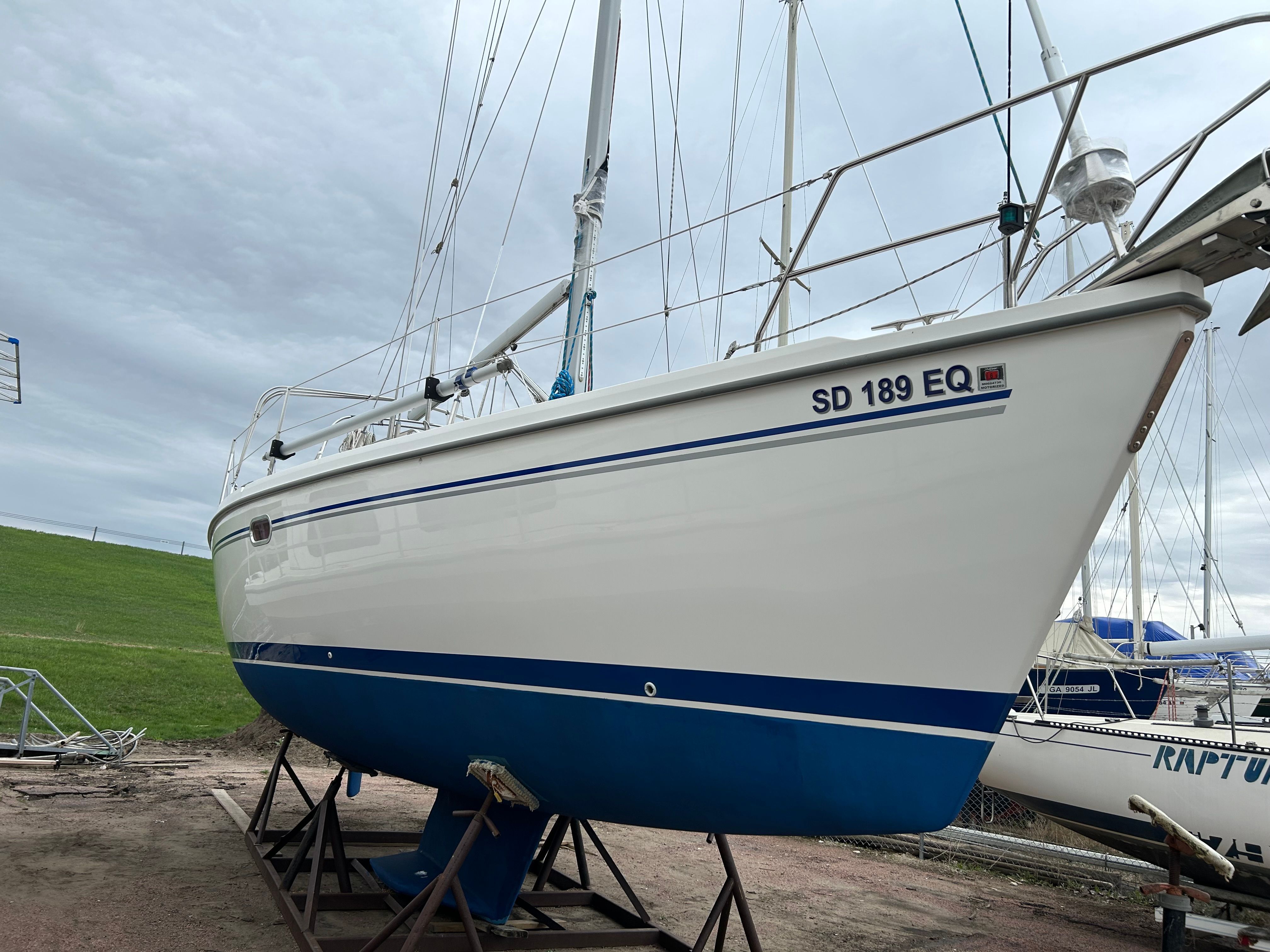 A 2004 Catalina 350 sailboat is on a stand on land.