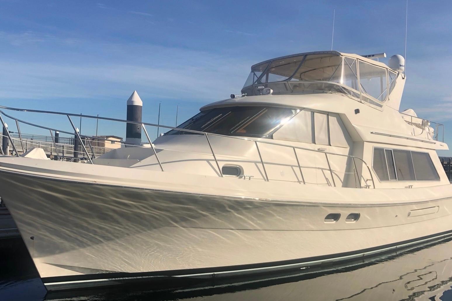 Luxury 2002 Hampton 550 yacht docked under clear blue sky.