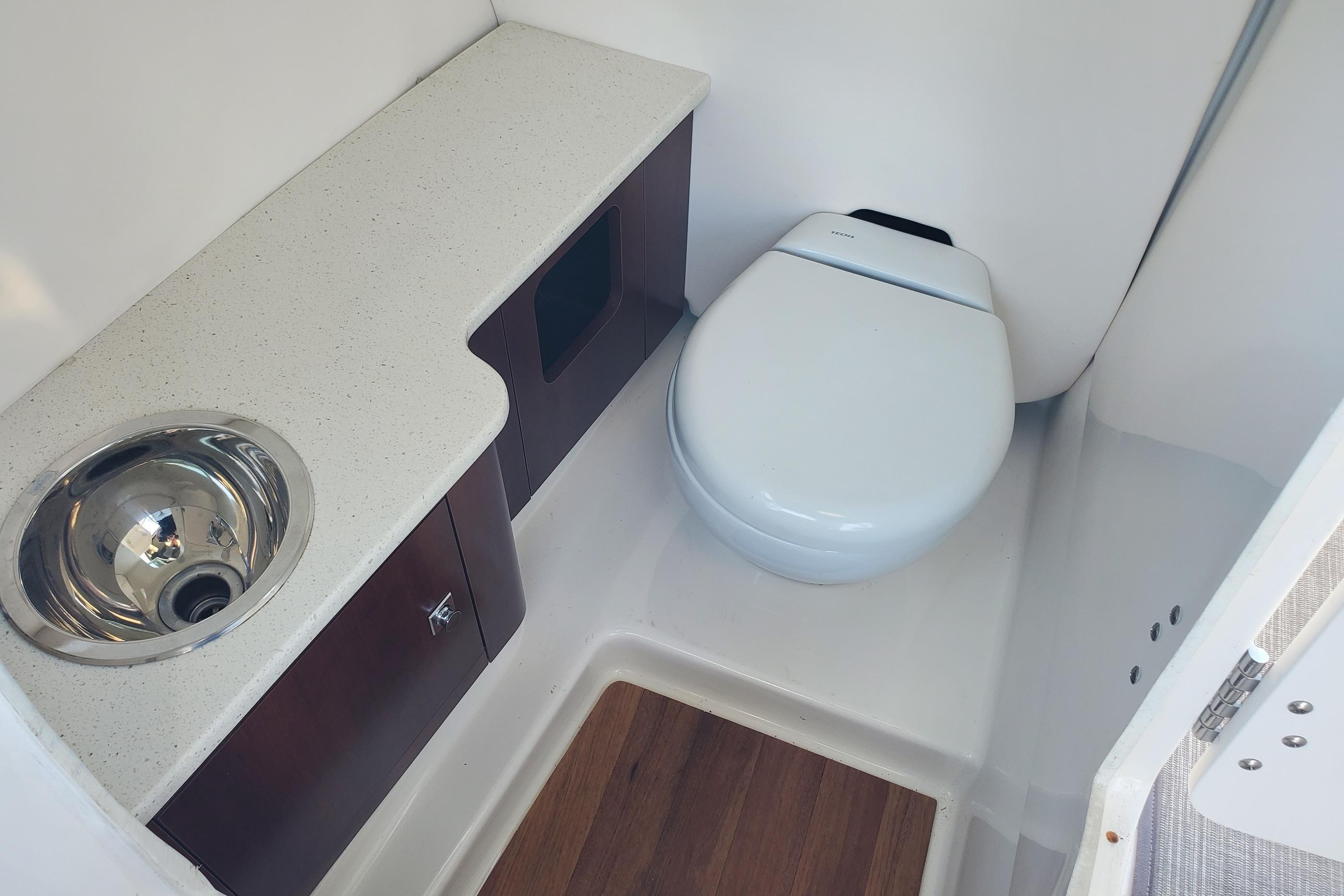 2021 Robalo R247 Dual Console boat bathroom with sink and toilet.