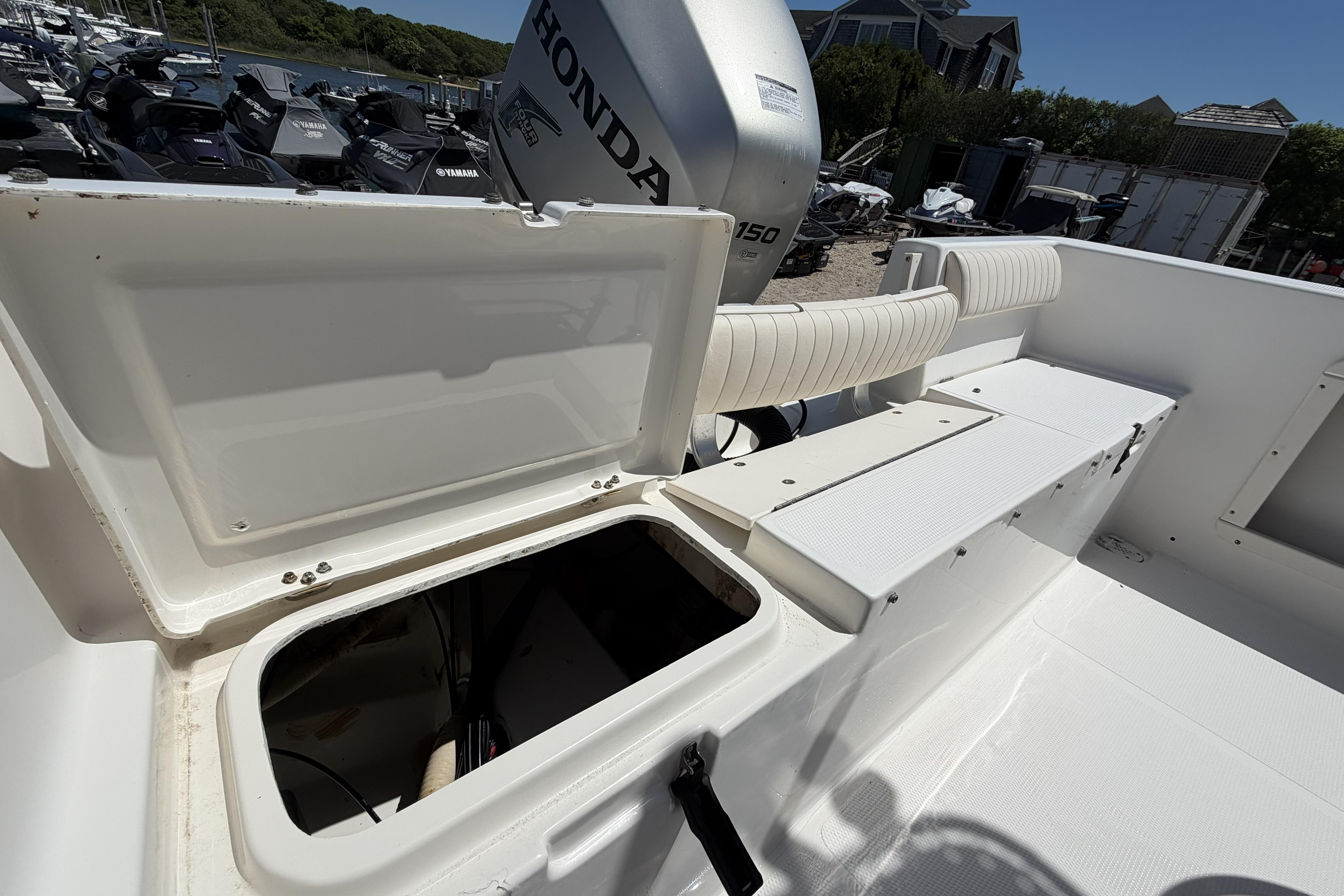 2006 Mako 212 Center Console boat with open storage compartment and Honda engine.