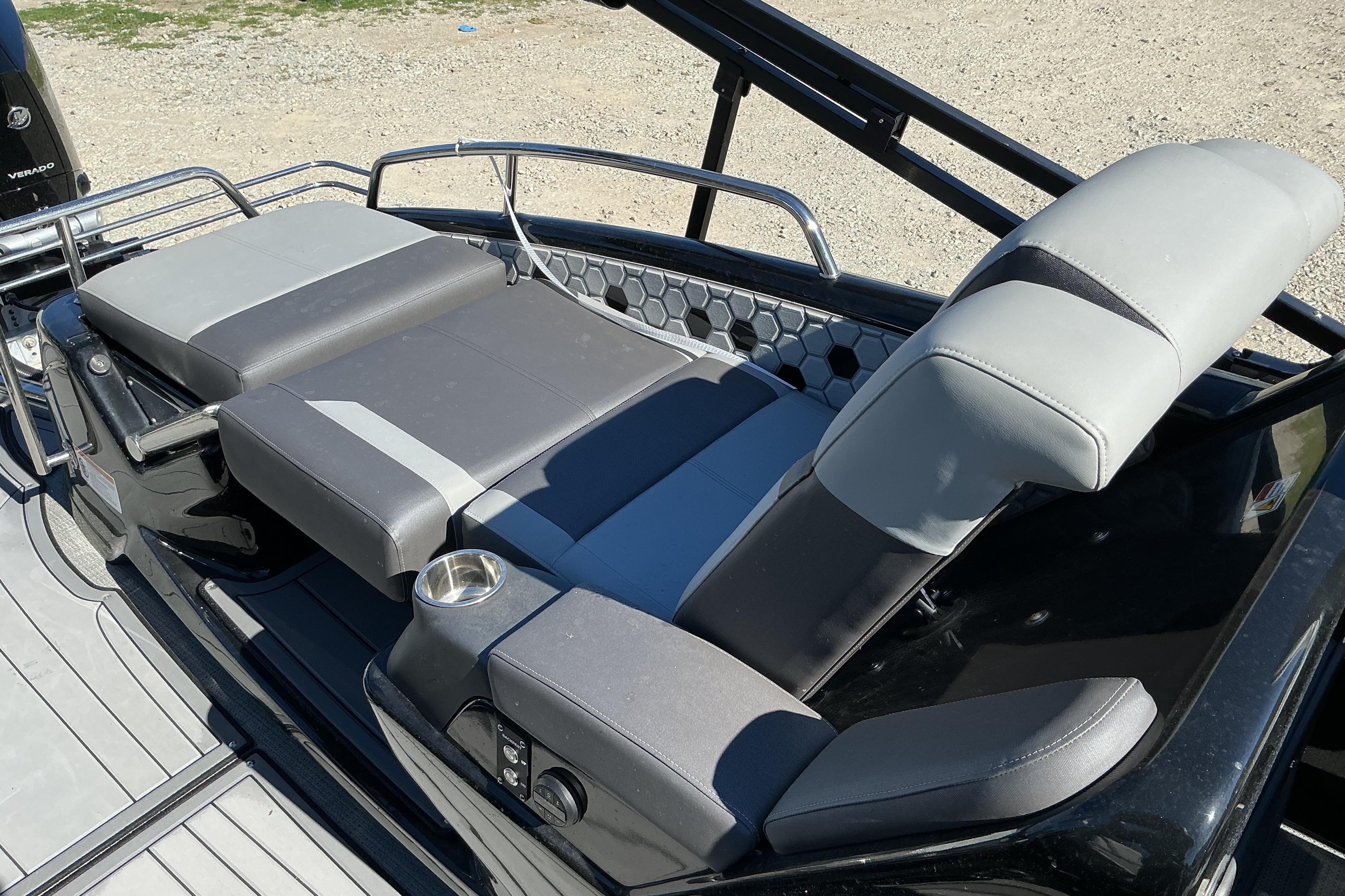 2024 Manitou 25 X-Plode XT SRS boat seating with sleek gray upholstery and cup holder.